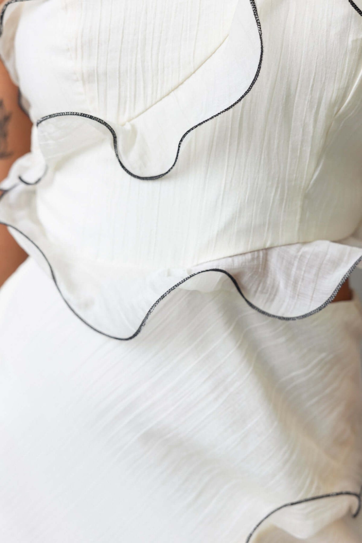 Close-up of the Clouded Maxi Dress showcasing textured material and ruffled detailing with black trim.
