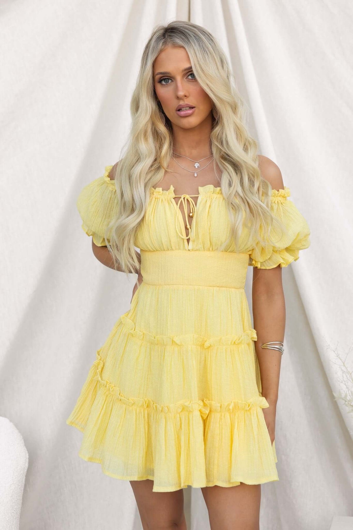 Bright yellow textured dress with off-shoulder neckline and ruffled hem, perfect for summer events.