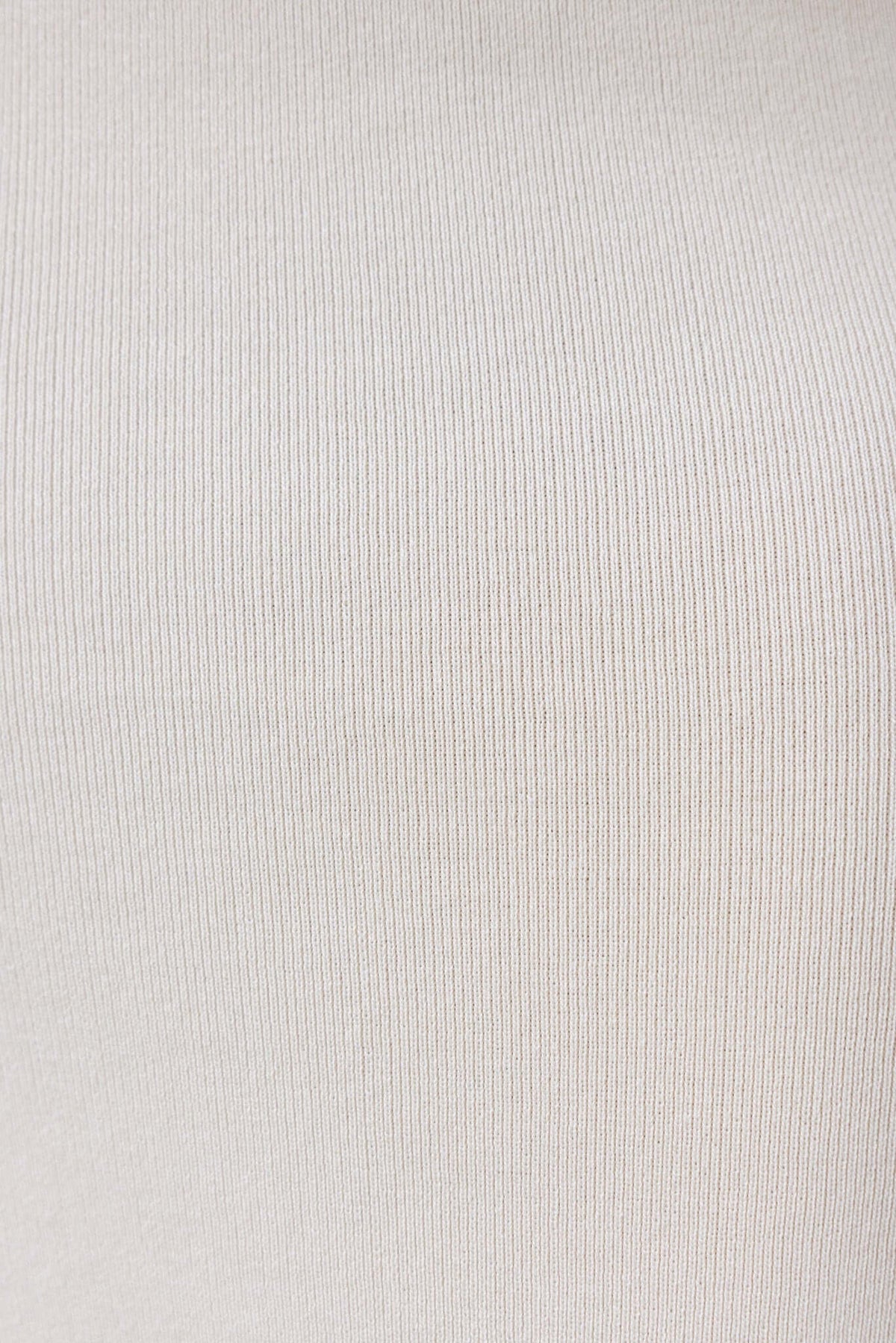 Close-up of soft ribbed knit fabric in a neutral color, showcasing its texture and stretch.
