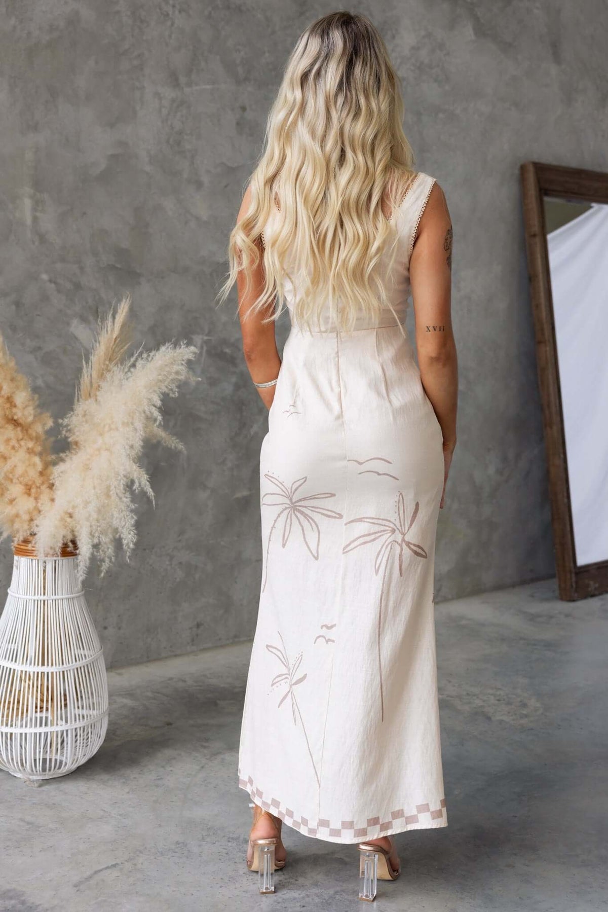 Back view of a woman in a Norris Maxi Dress with palm tree embroidery, showcasing lightweight fabric and a stylish design.