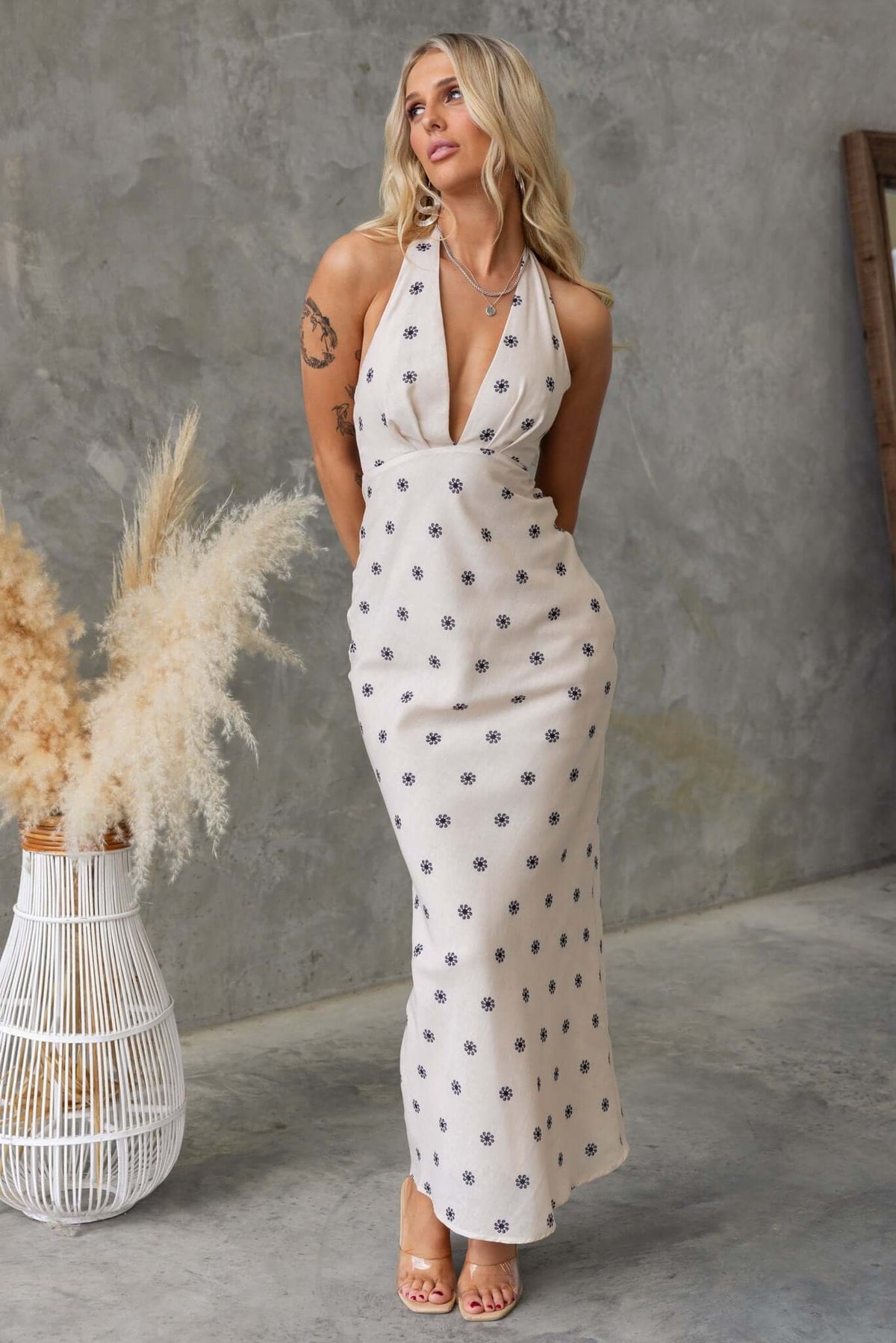 Model wearing Fulton Maxi Dress with adjustable tie straps and polka dot design, set against a textured backdrop.