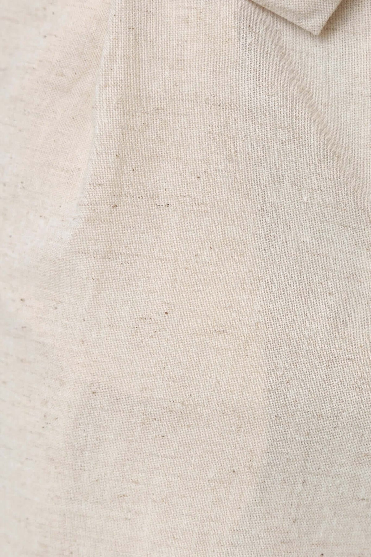 Close-up of textured cream-colored fabric showcasing a cotton look and feel for the Fallon Set.