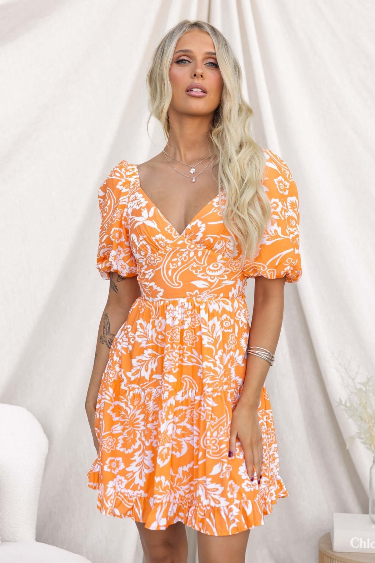 Omaha Dress featuring an orange floral print, short puff sleeves, and a flattering fit.