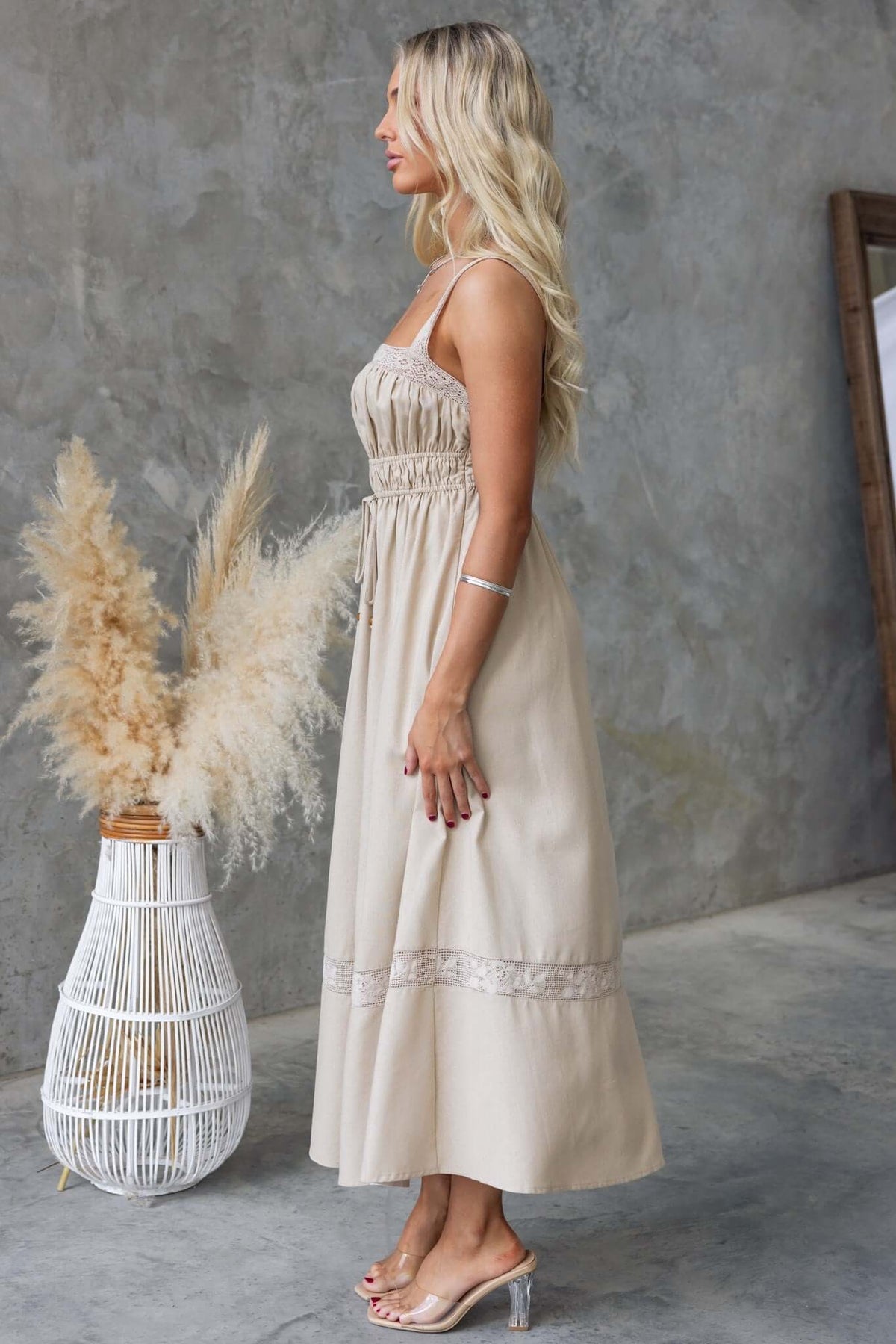 Side view of Eletti Midi Dress featuring lace detailing, elastic waistband, and tied waist in neutral tone.