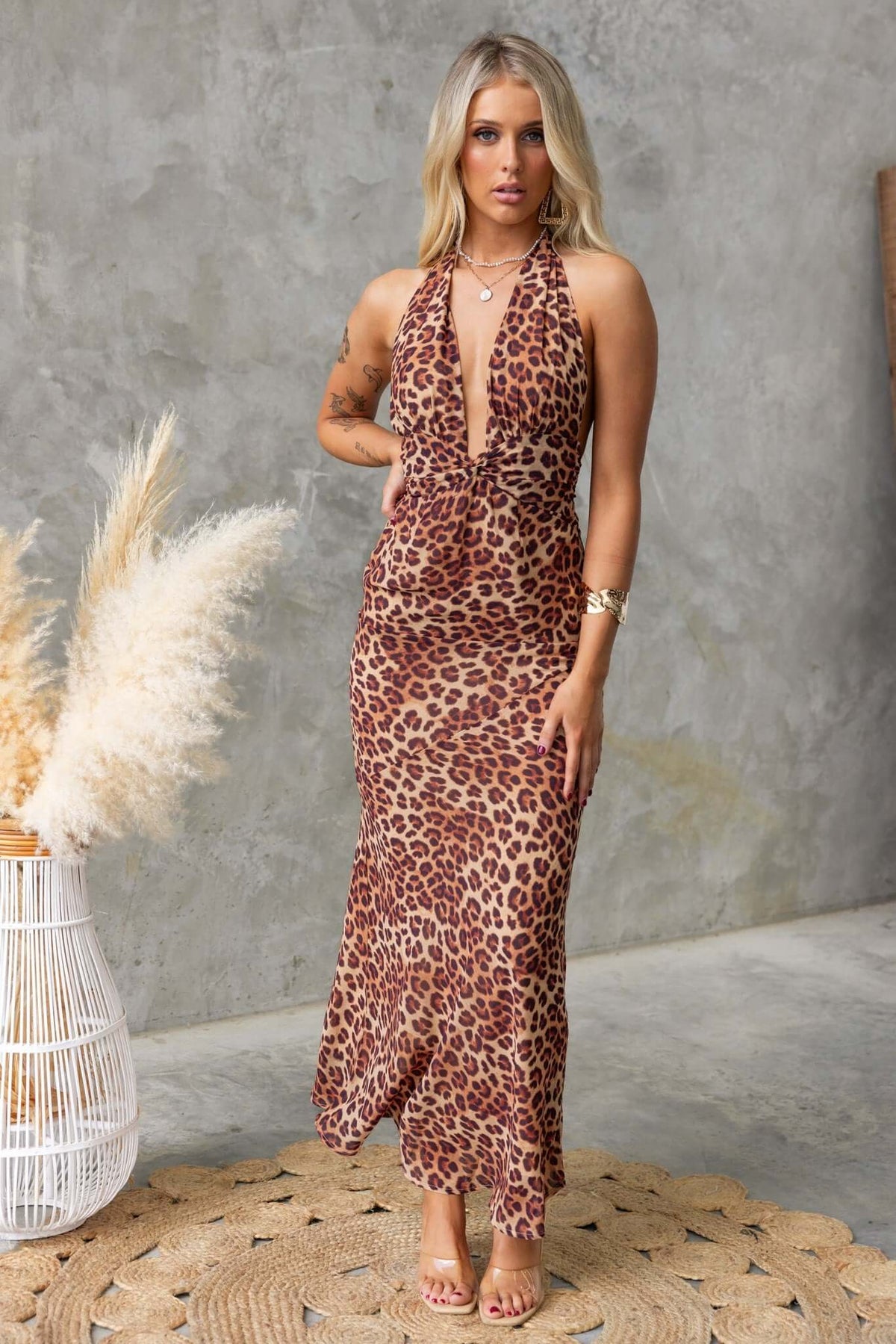 Model wearing a leopard print Bronx maxi dress with adjustable tie neckline and back zip, styled on a neutral background.
