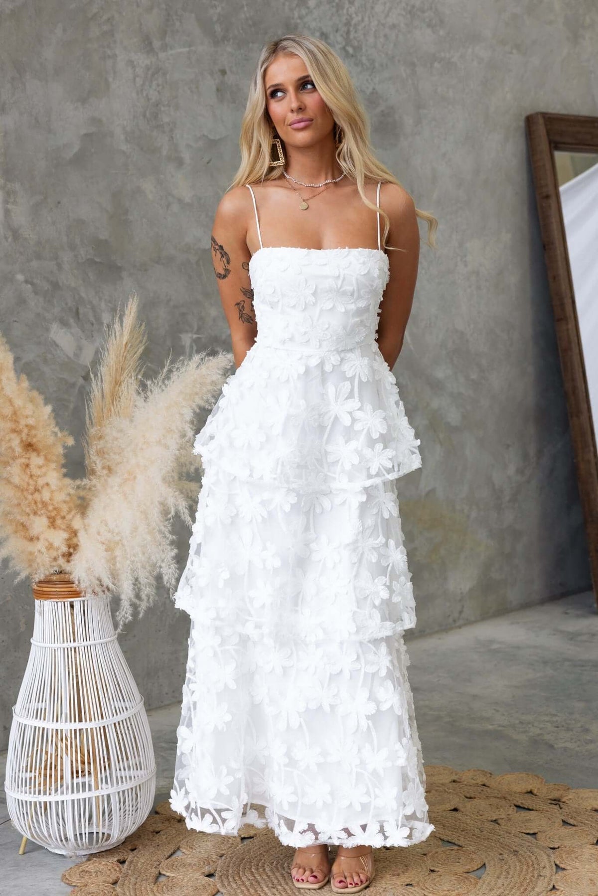 Jeannette Maxi Dress with adjustable straps, made of lace material, featuring a tiered design in white.