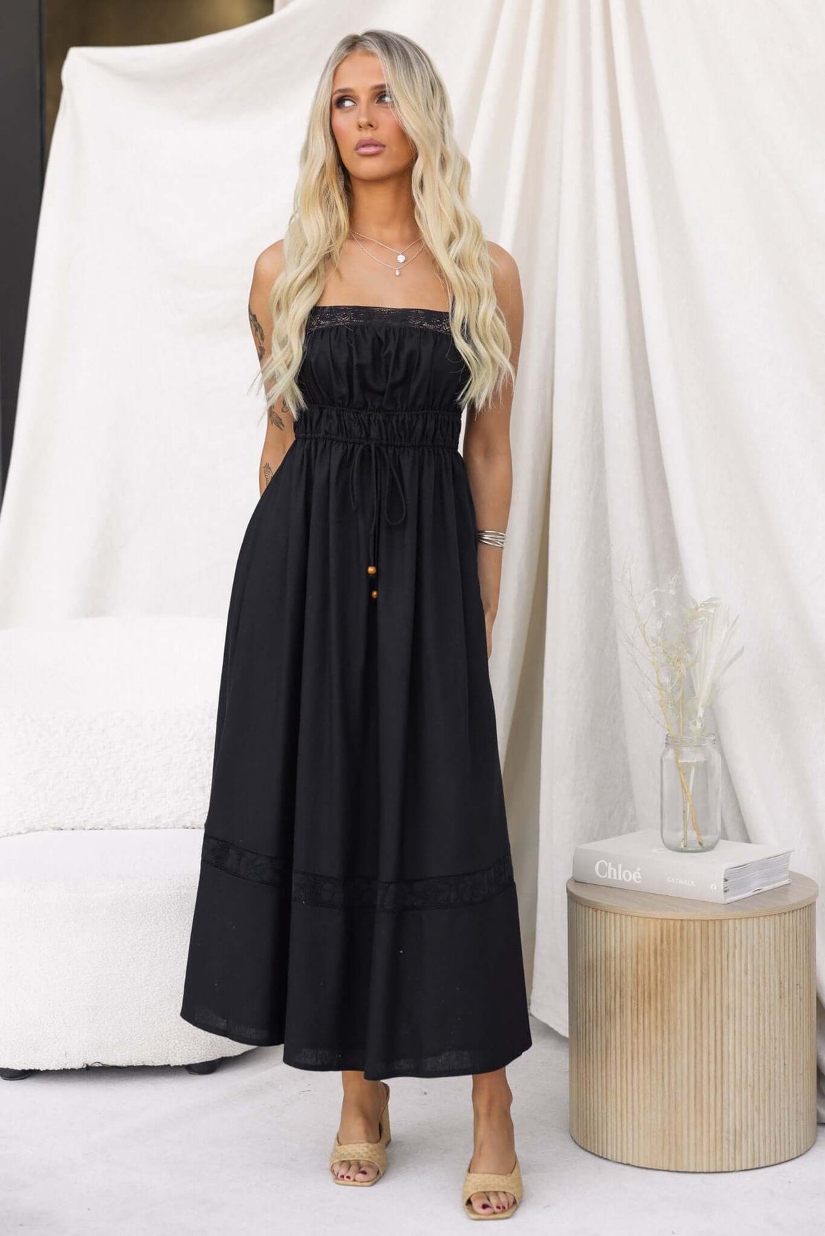 Black Eletti Midi Dress featuring lace detailing, elastic waist, and stylish tie. Elegant and lined for a comfortable fit.