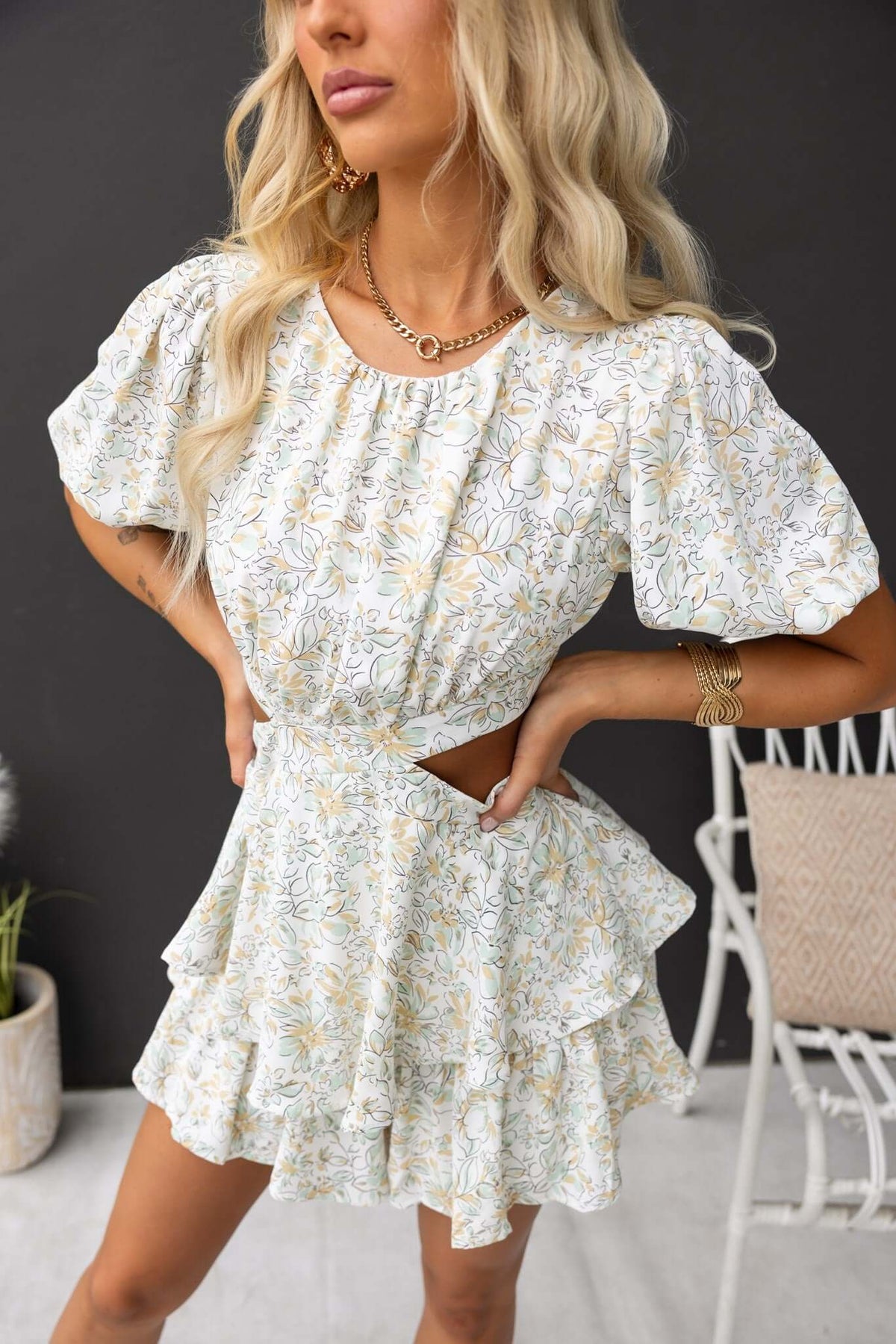 Model wearing a floral dewy playsuit featuring puff sleeves and a cut-out design.