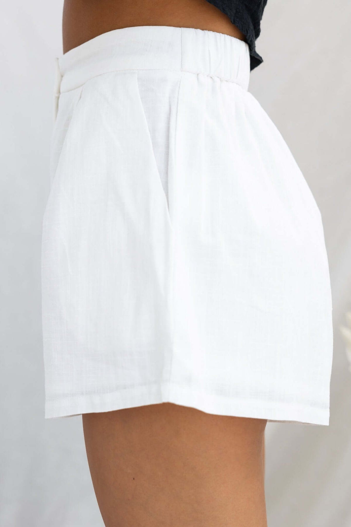 Ciaran Shorts in white, featuring a mid-high waist, elastic waistband, and pockets for comfortable casual wear.