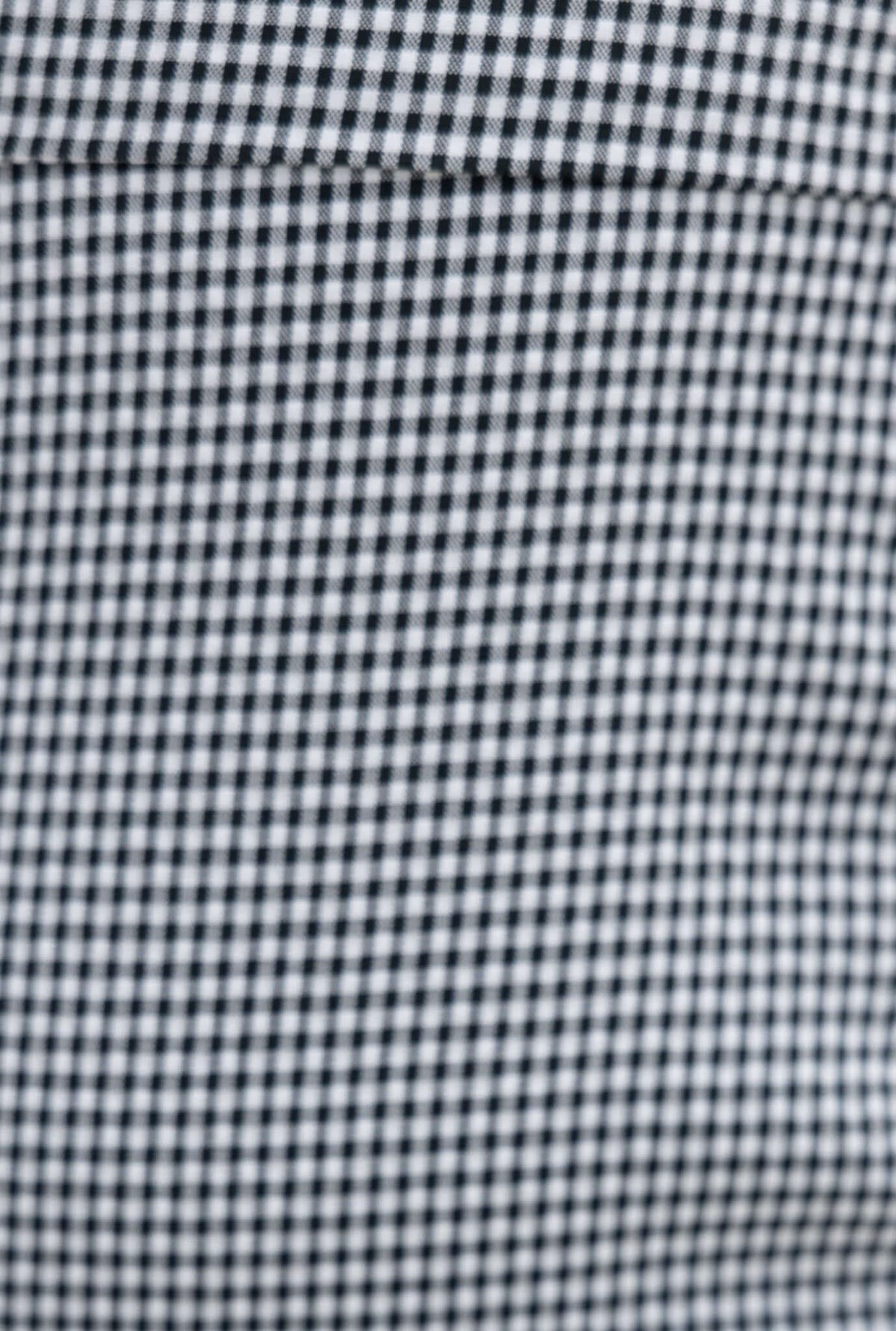 Close-up of black and white checkered fabric pattern suitable for clothing design.