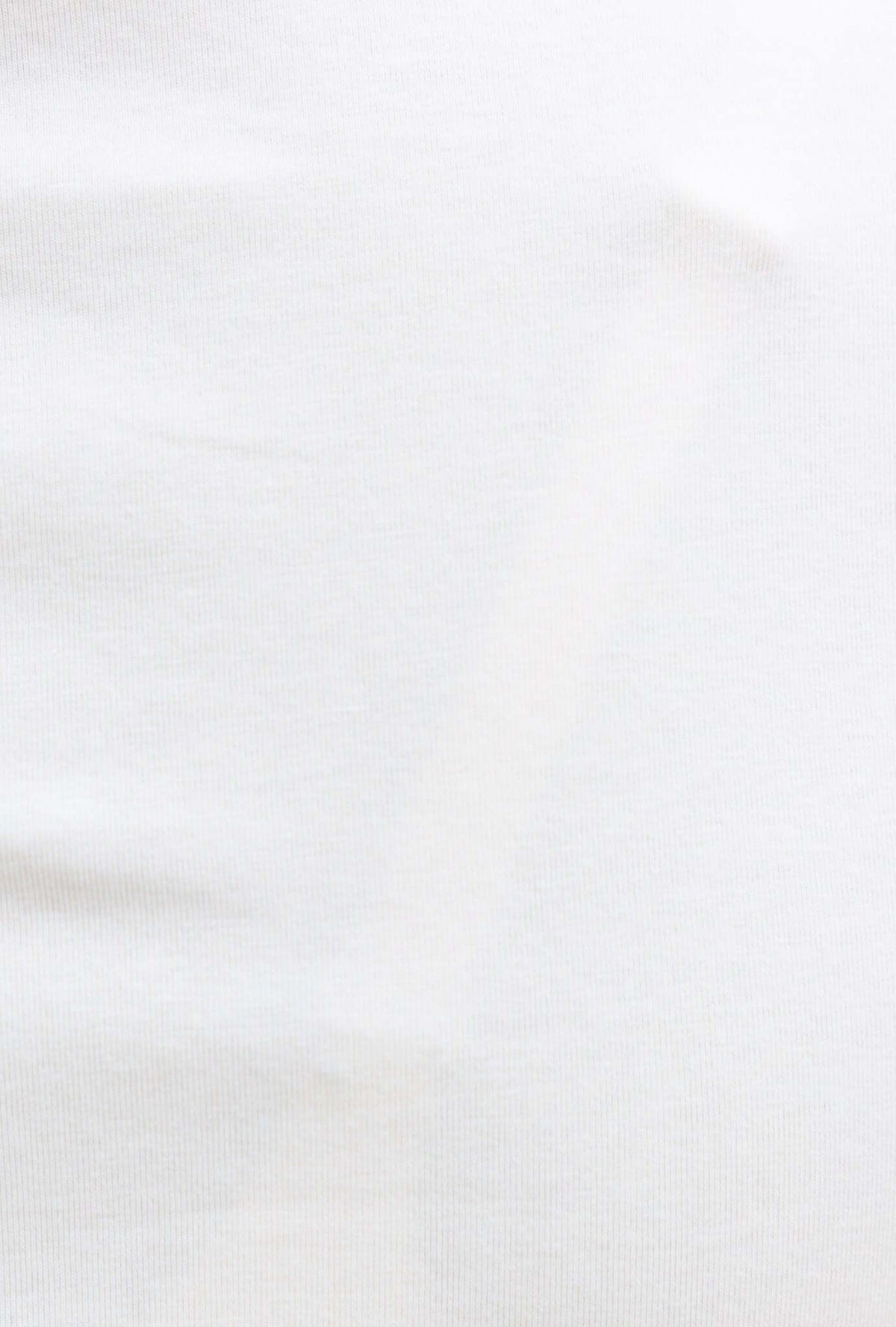 Close-up of the soft, stretchy white fabric of the Daisy Tee with a smooth texture.
