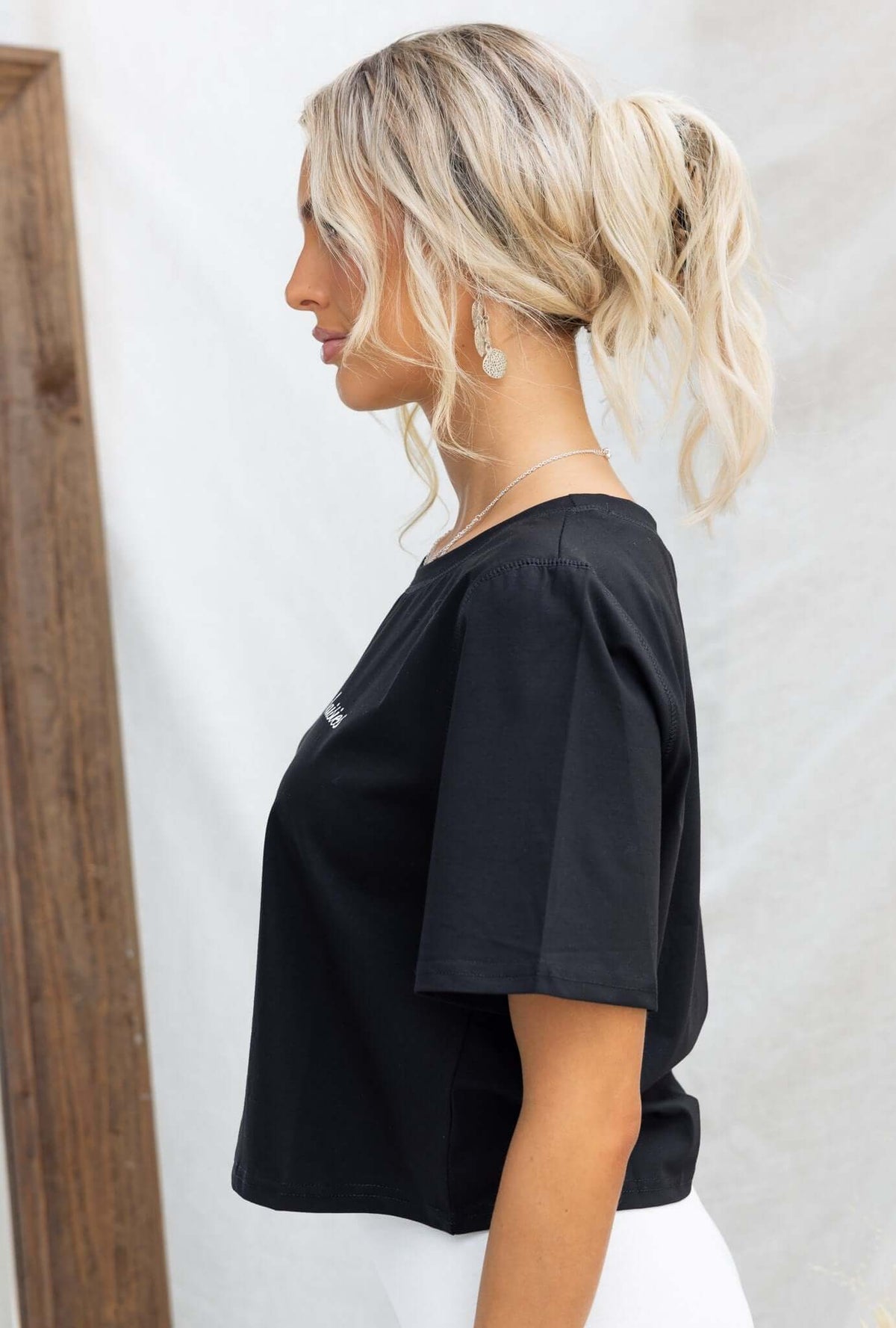 Black oversized Daisy Tee with round neckline worn by a model, showcasing a relaxed fit and soft cotton blend.