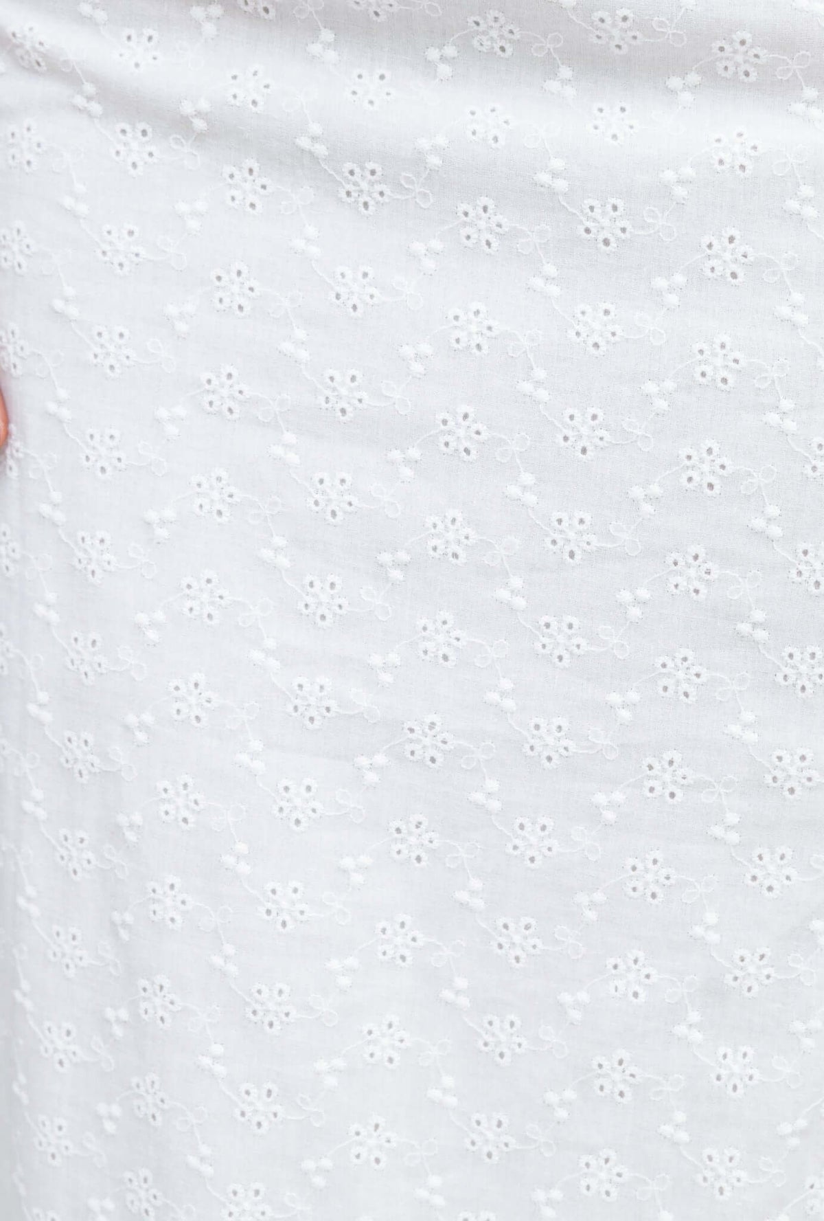 Close-up of white Anglaise fabric with floral pattern, ideal for the stylish Olivine Top.