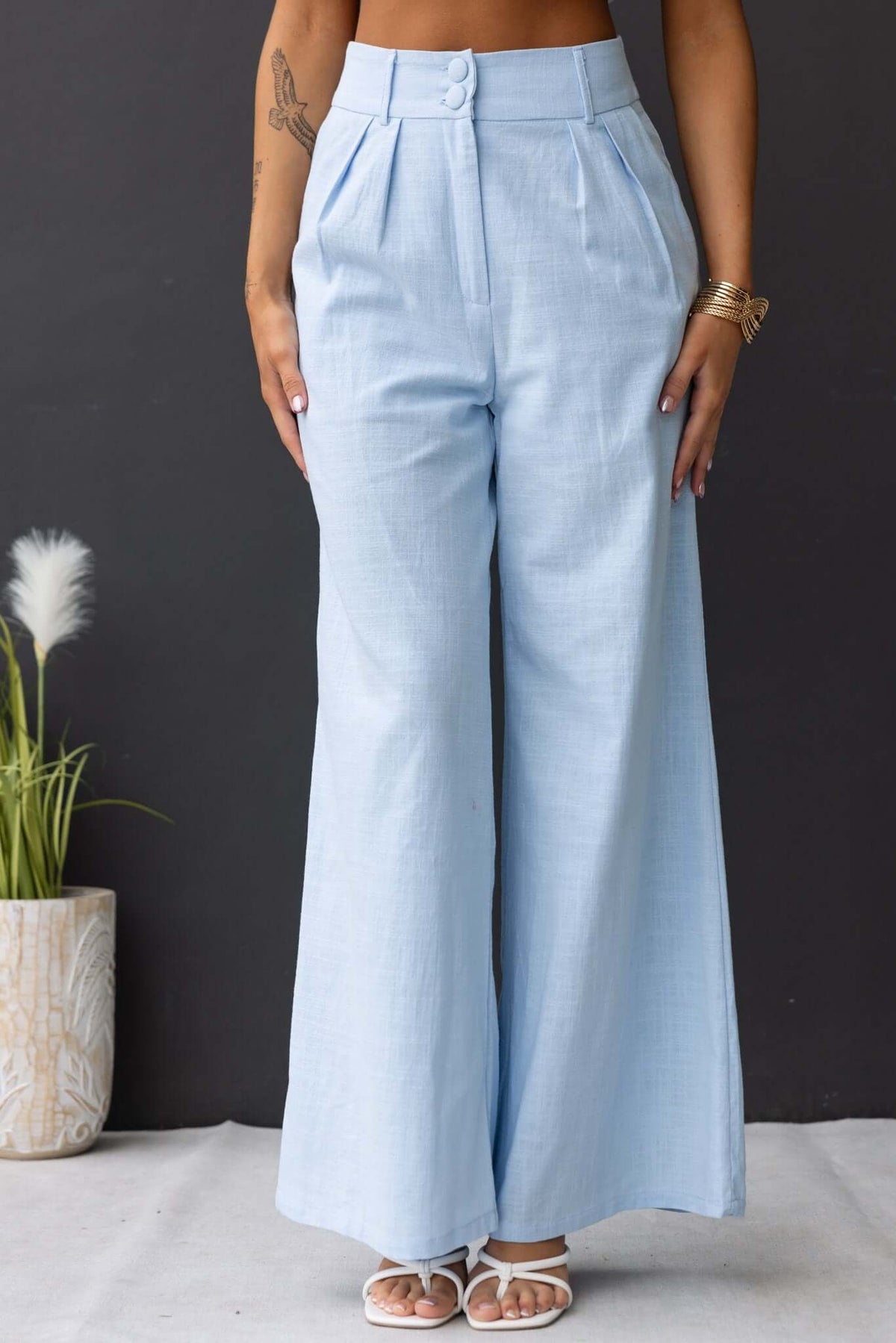 Light blue Socorro Pants with mid-high waist and wide legs, styled for a fashionable look.