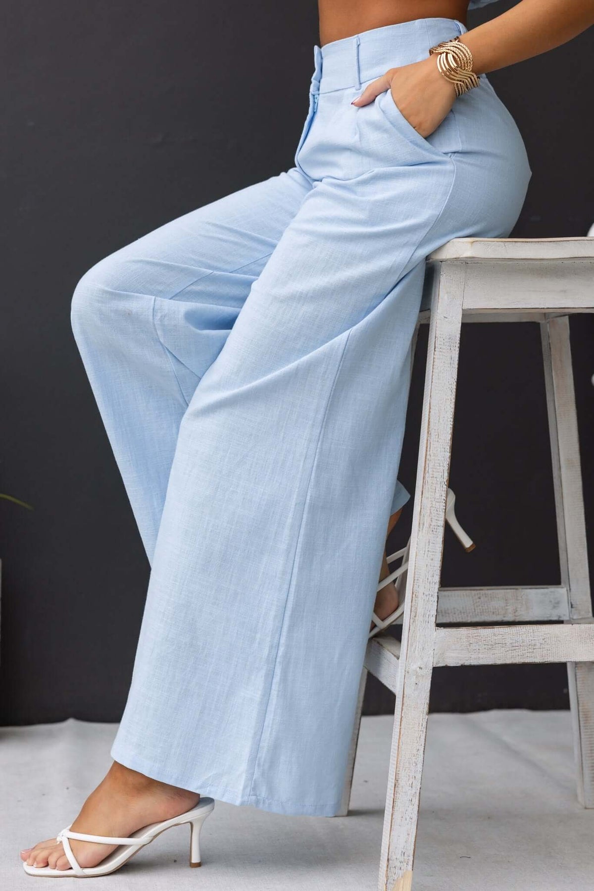 Light blue Socorro Pants with mid-high waist, pockets, and elastic waistband, styled with a casual look.