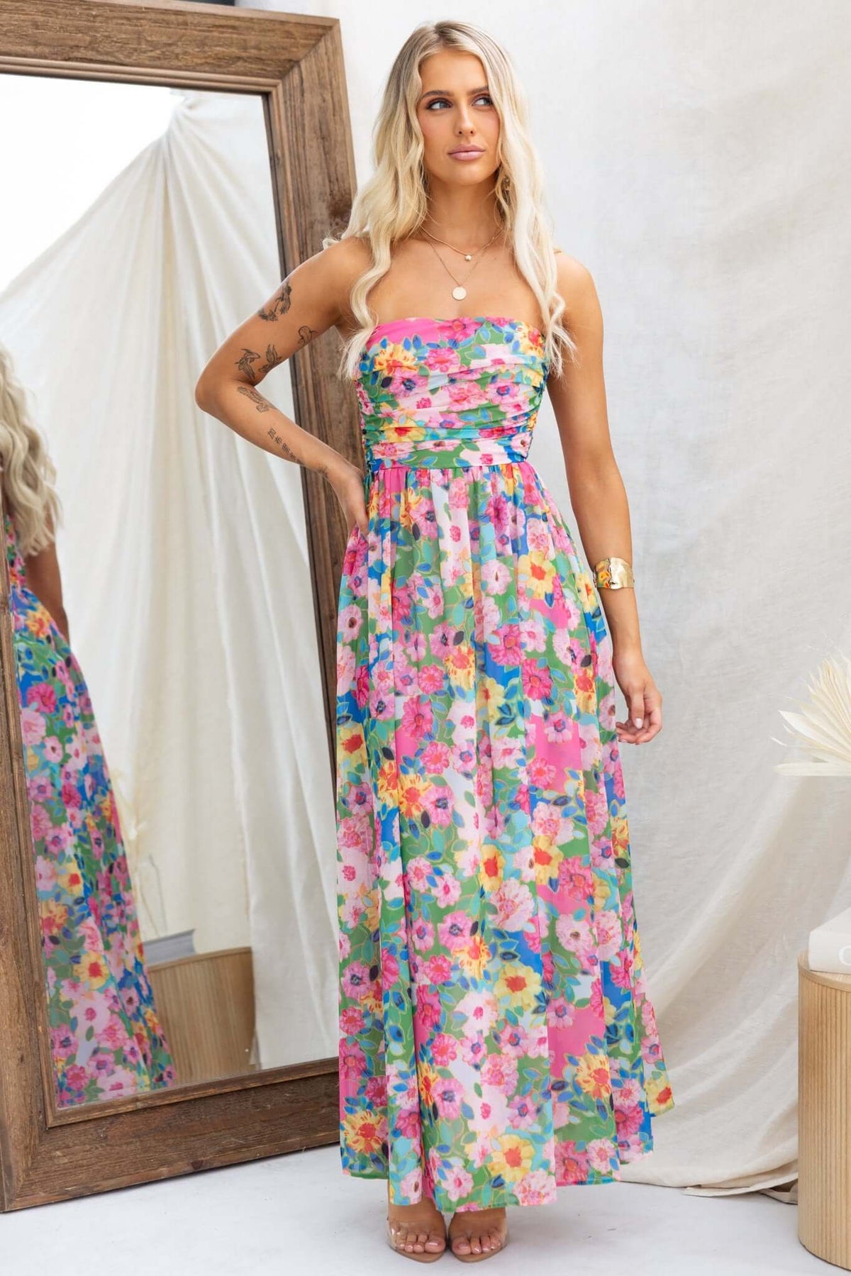 Strapless Emberia Maxi Dress featuring a vibrant floral print, with a fitted bust and flowing skirt, styled by a model.