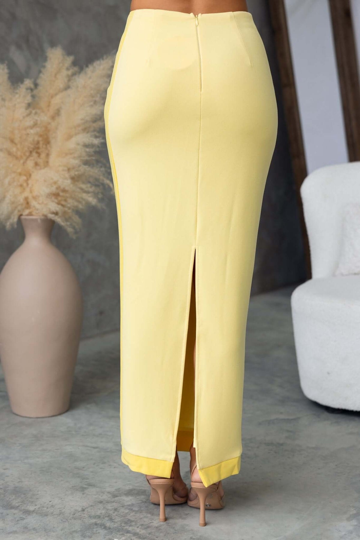 Back view of a yellow Rianna Maxi Skirt featuring a mid-high waist and a back split design.