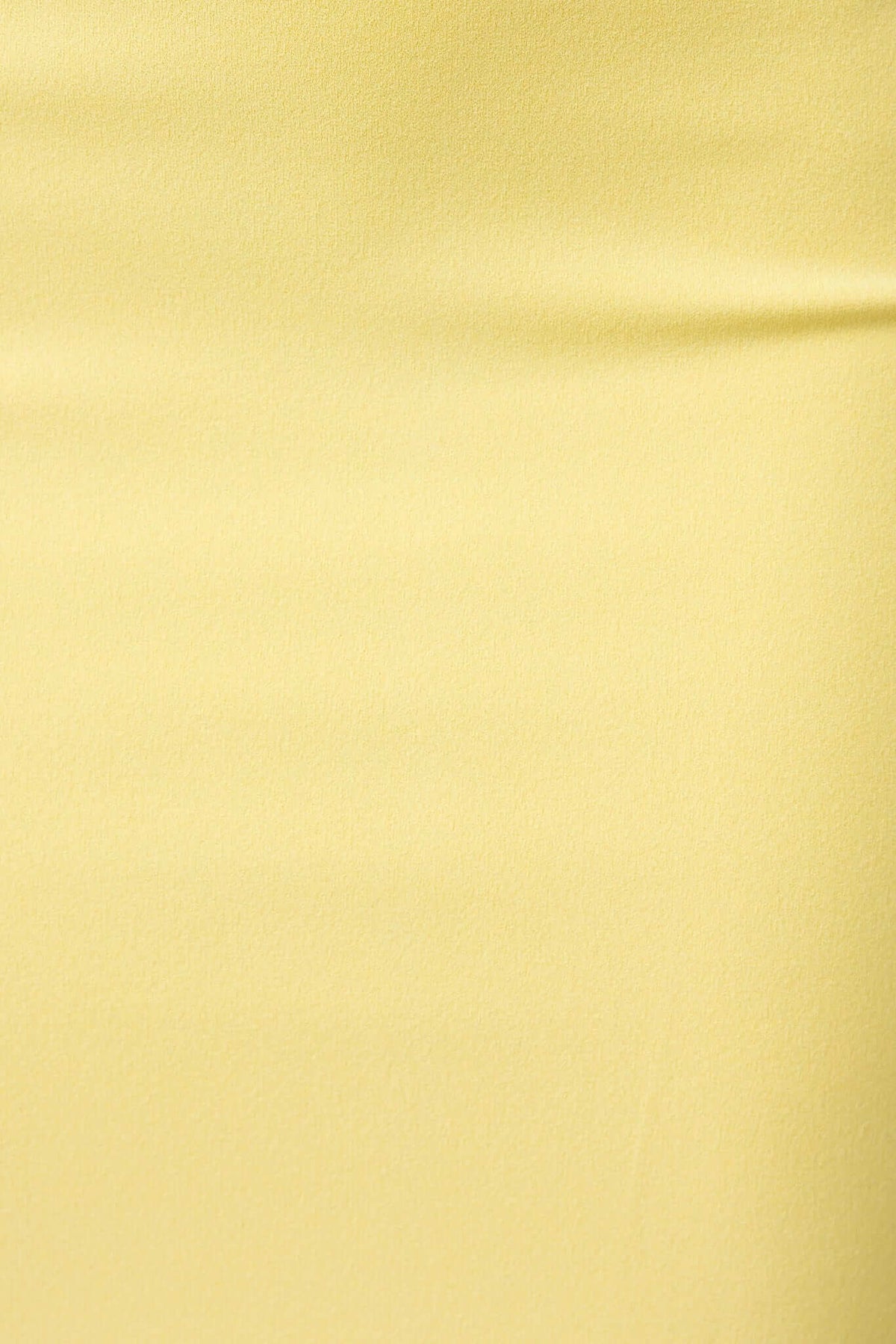Close-up of lightweight yellow fabric showcasing its smooth texture and stretch, perfect for a stylish top.
