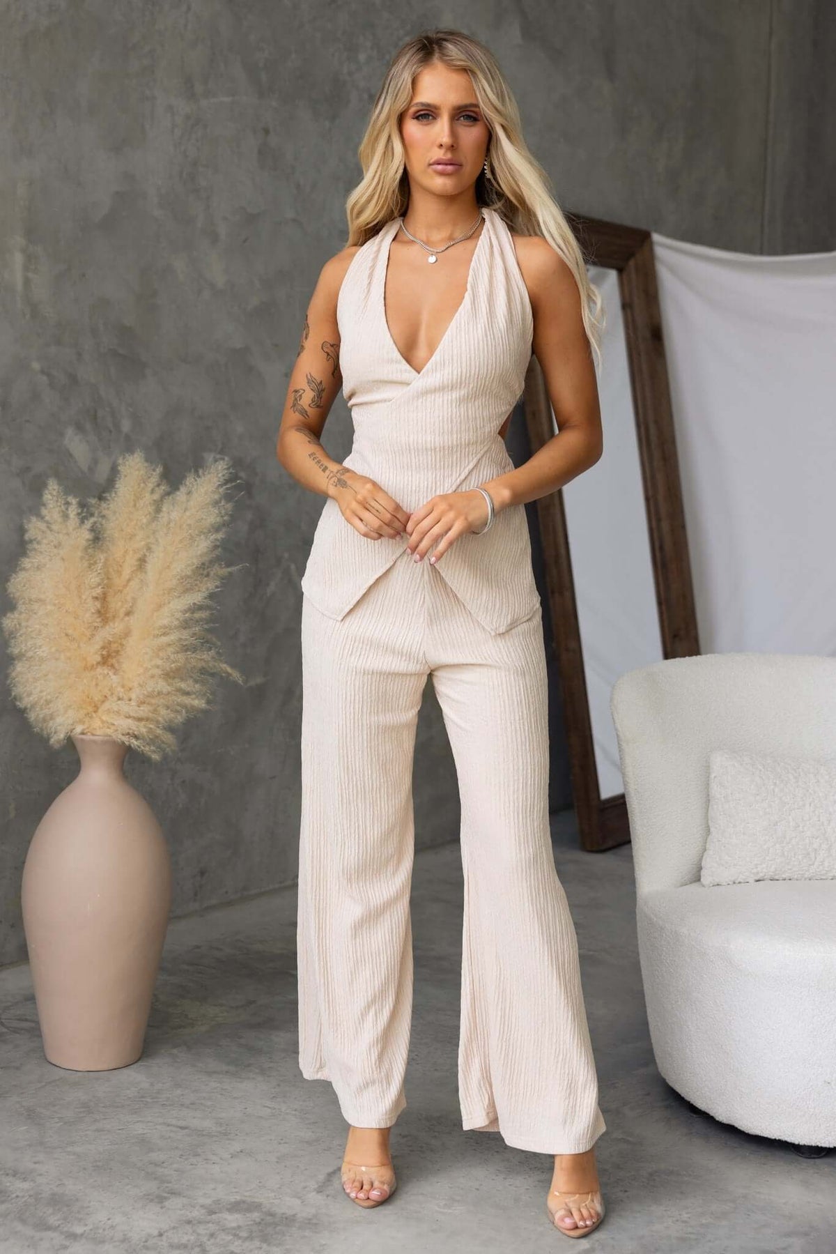 Model wearing a beige Lisa Top with wrap tie neckline, showcasing a stylish and textured design.