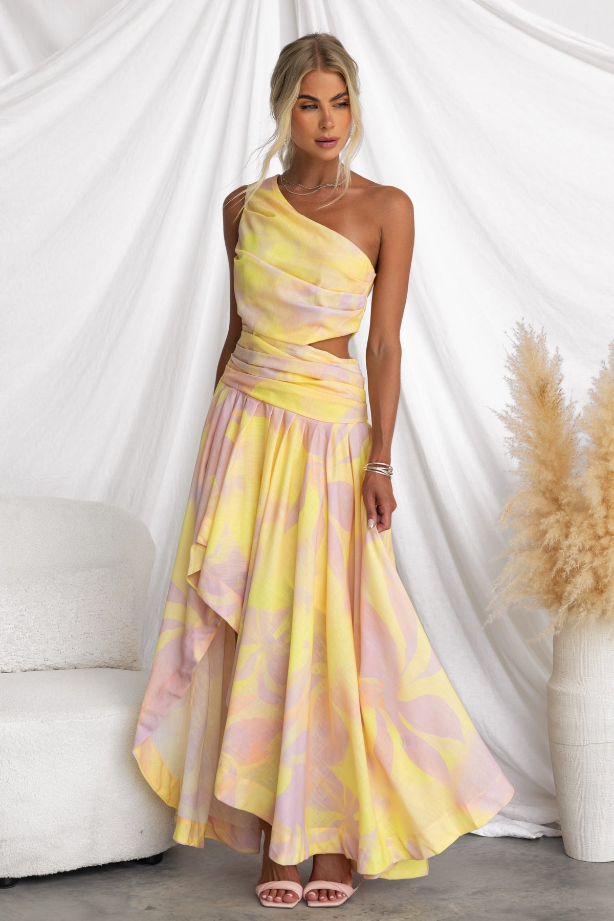 Horizons Maxi Dress in multi-colour with one-shoulder neckline and asymmetrical hem on a model against a soft backdrop.
