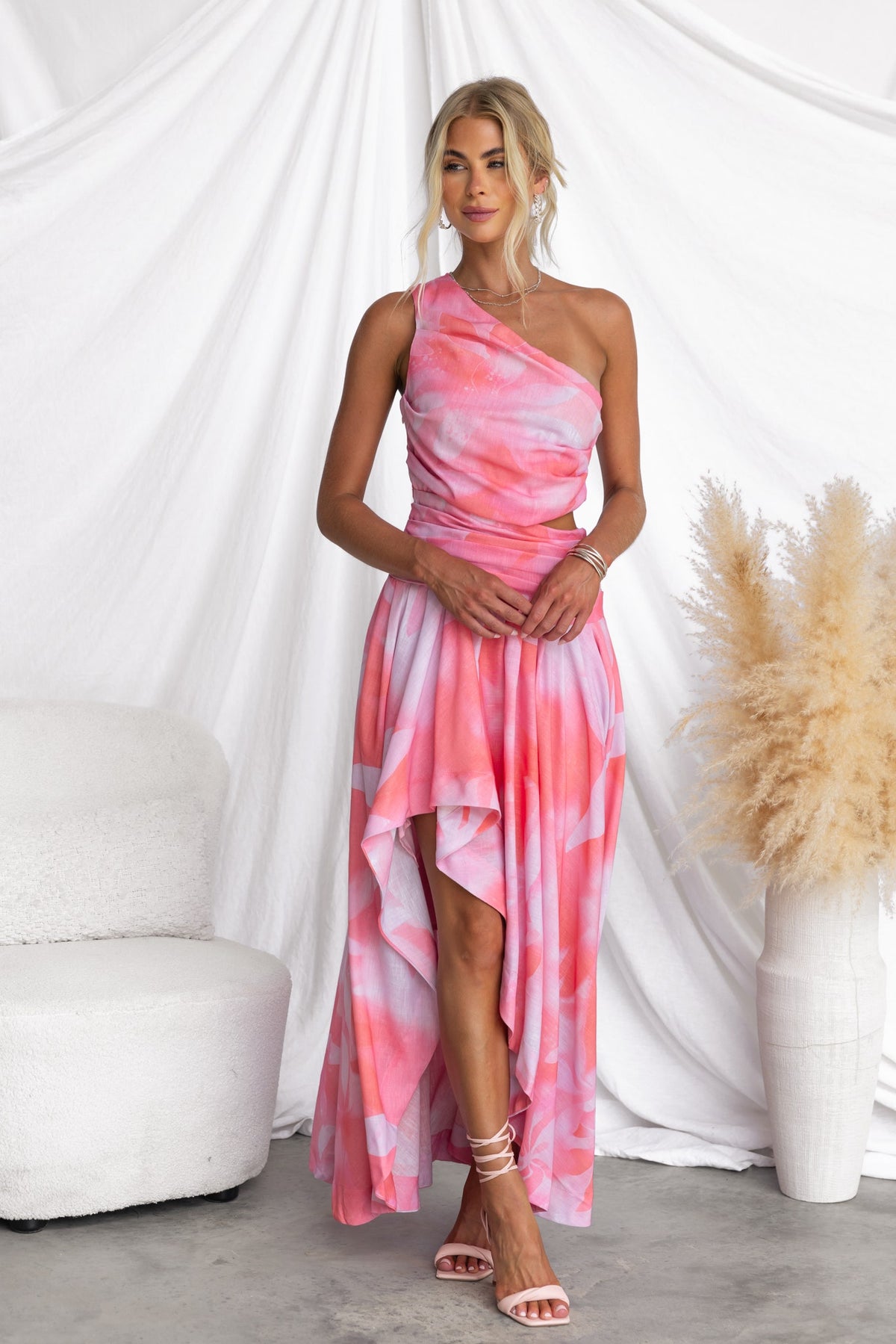 Model wearing Horizons Maxi Dress with one-shoulder neckline, pink tie-dye pattern, and asymmetrical hemline.