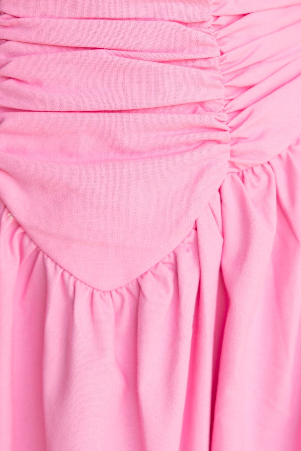 Close-up of the Abelle Maxi Dress in pink, featuring gathered fabric and a soft, textured finish.