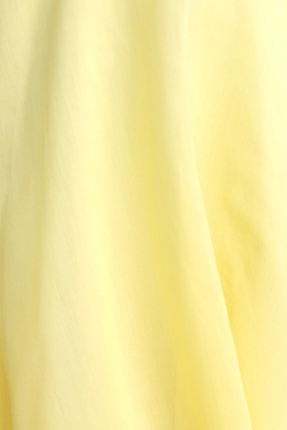 Close-up of soft yellow chiffon fabric, showcasing elegant texture for Reilan Midi Dress.