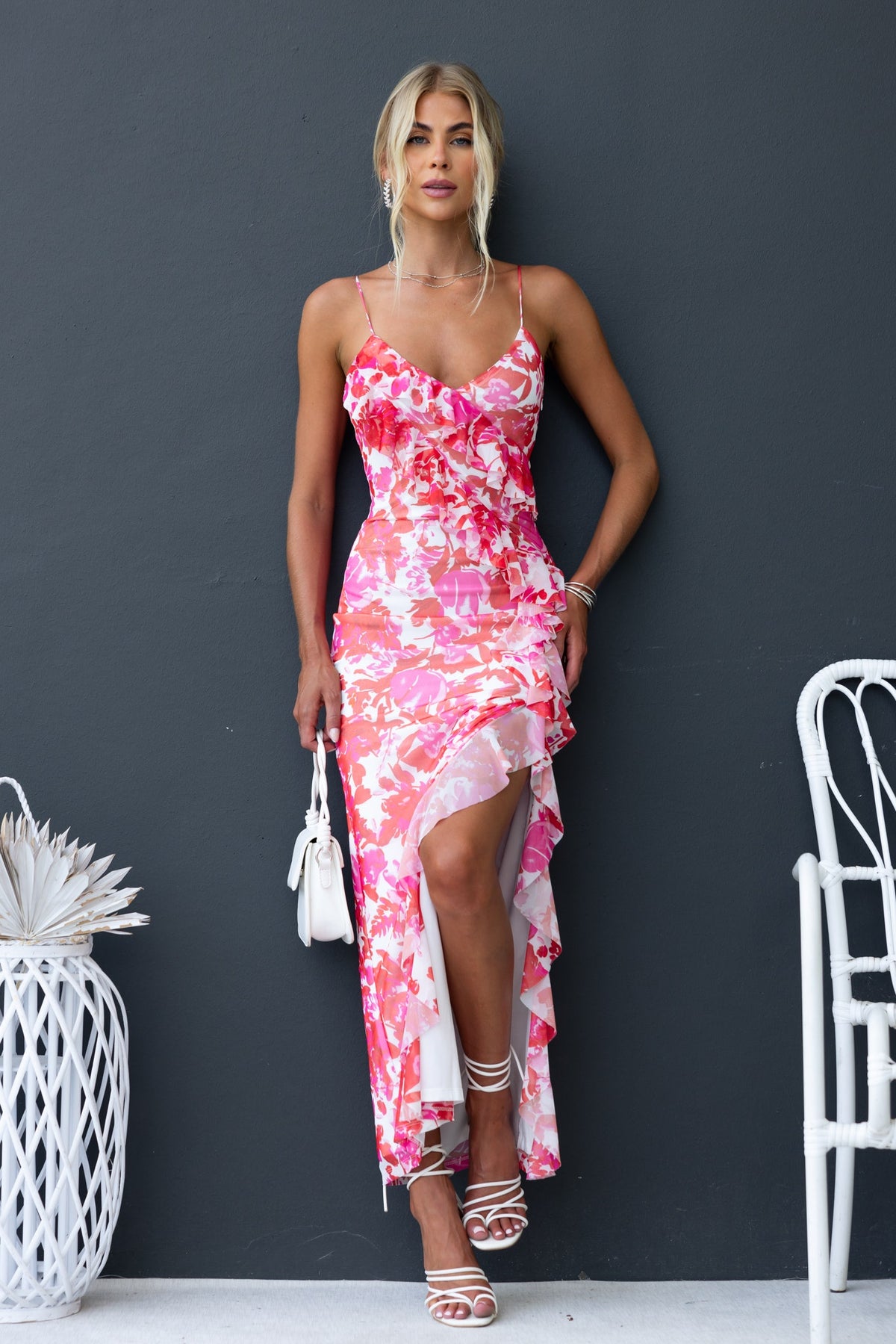 Model in a floral print Jillian Maxi Dress with adjustable straps and ruffle detailing, showcasing a chic summer look.