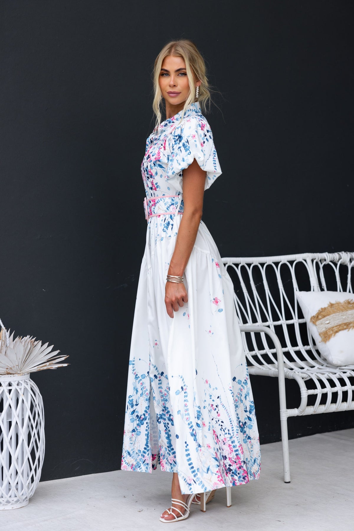 Model wearing Younger Now floral maxi dress with high neckline and button-up front, set against a sleek background.