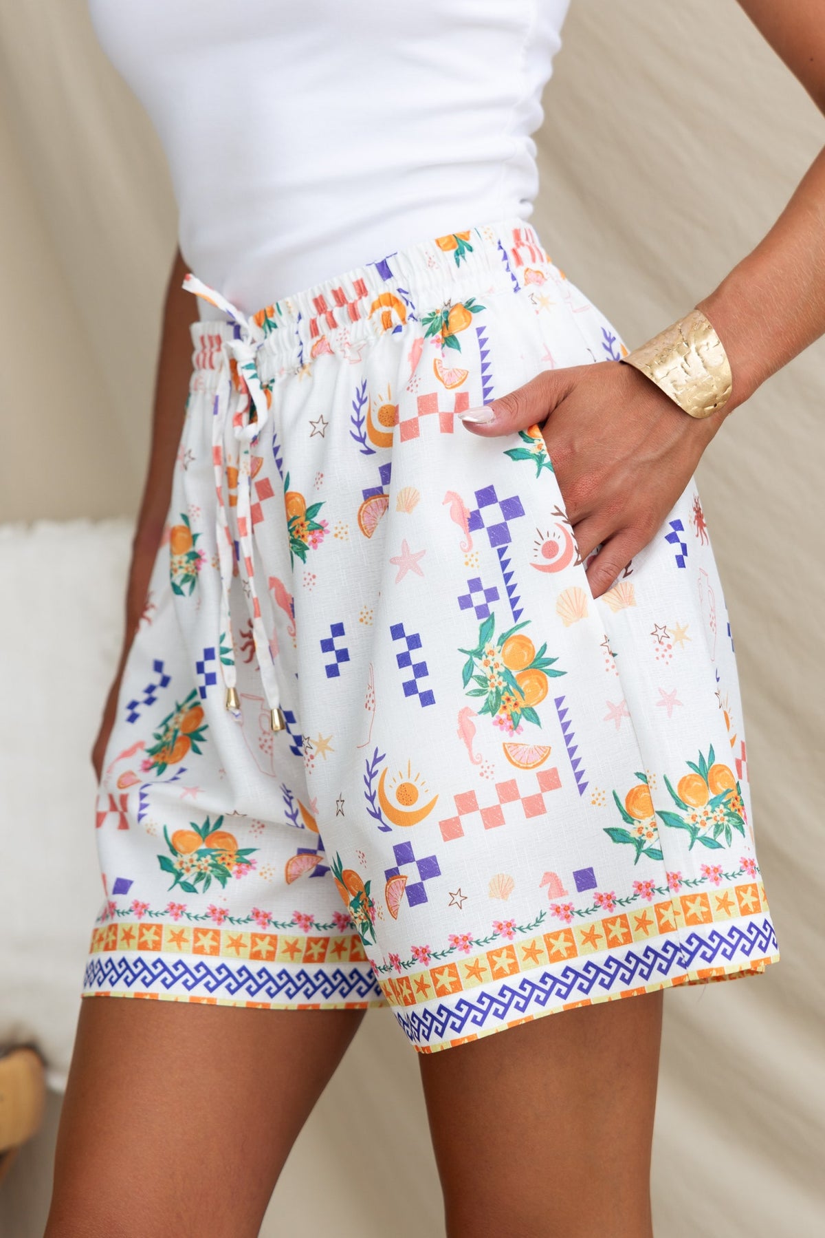 Talei Shorts featuring an abstract print, mid-high waist fit, elastic waistband, and pockets for a stylish summer look.