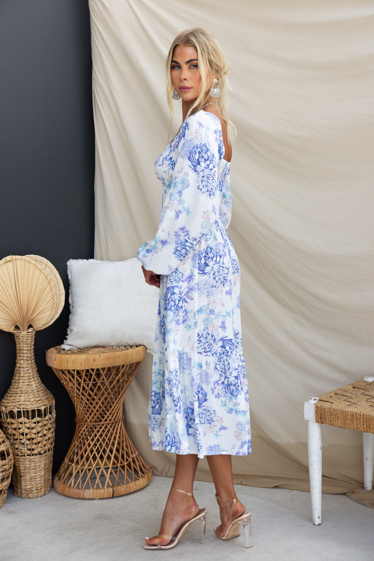 Celesta Midi Dress in floral print, featuring elastic sleeves and twist detail, styled with heeled sandals.