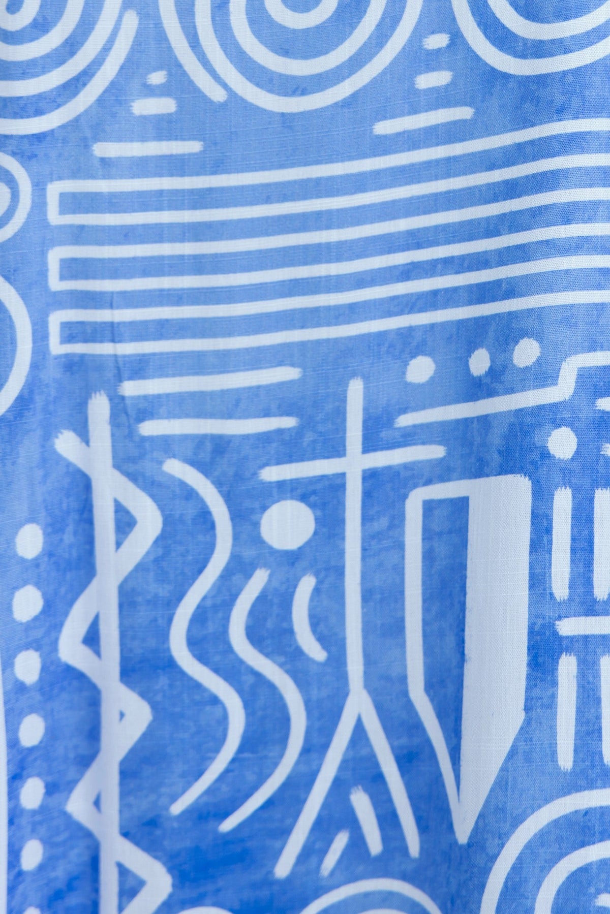 Abstract blue fabric with white geometric patterns and lines, perfect for stylish clothing designs.