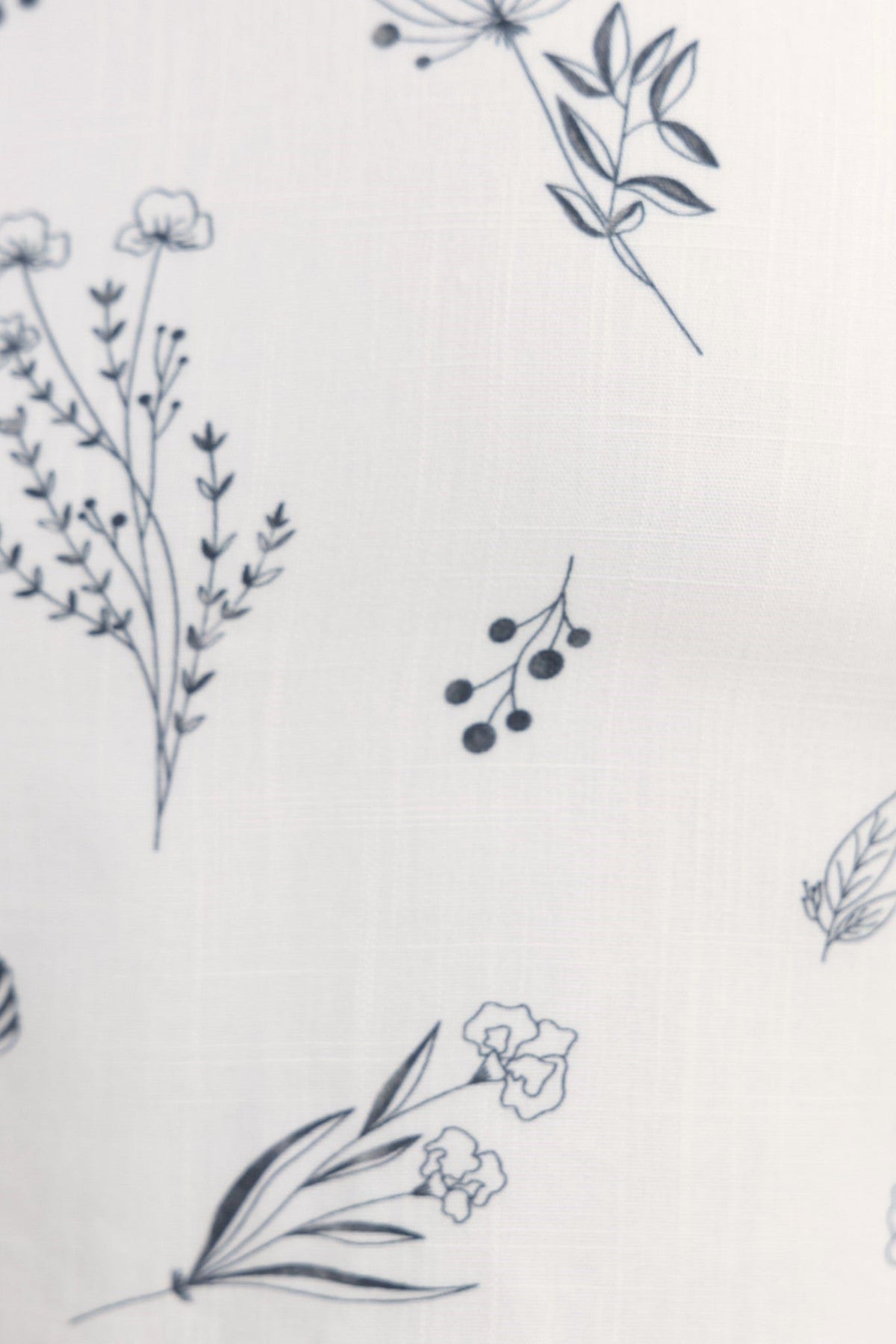 Floral print fabric design featuring various flowers and greenery in a delicate pattern.