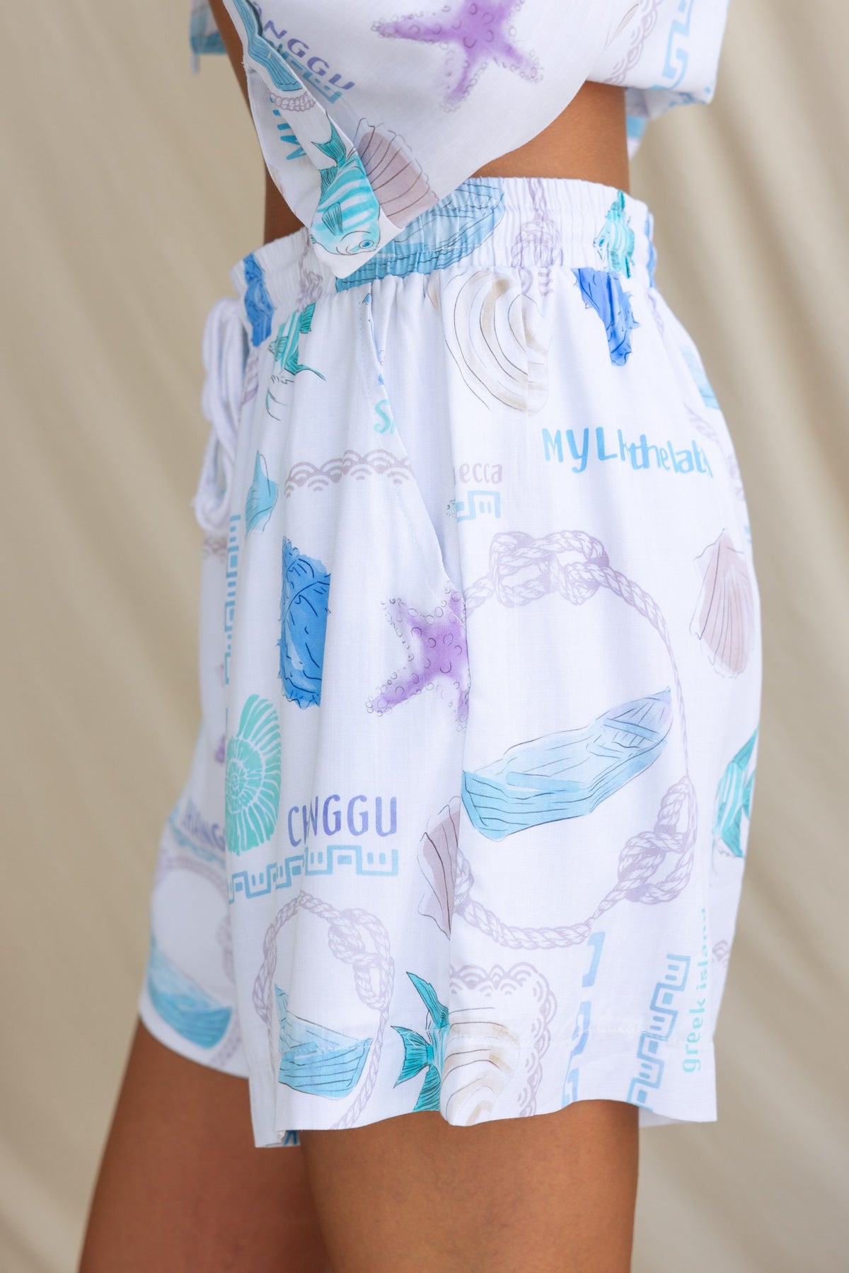 Oceania shorts featuring abstract print design, elastic waistband, and pockets, perfect for a stylish summer look.