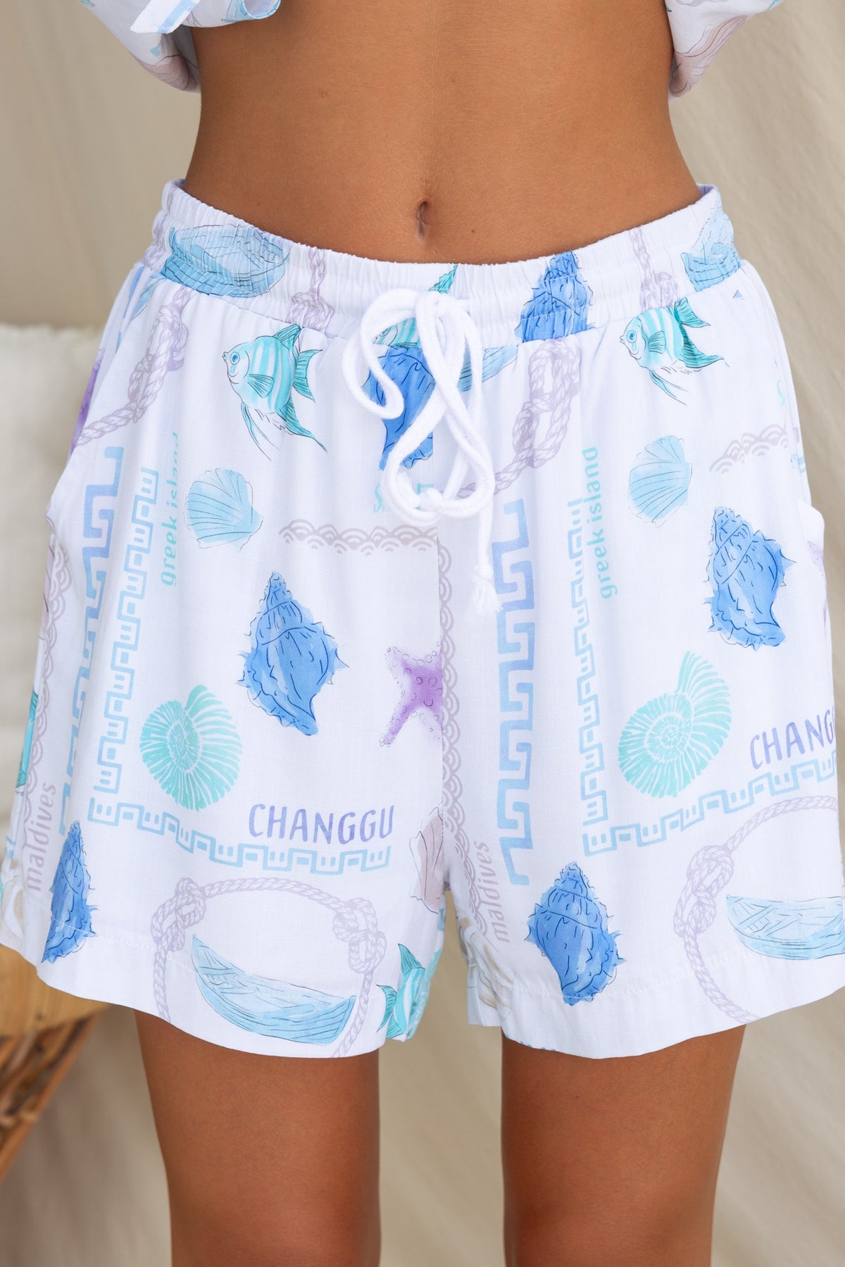 Oceania shorts with abstract sea-inspired print, elastic waistband, and pockets, perfect for a relaxed summer look.