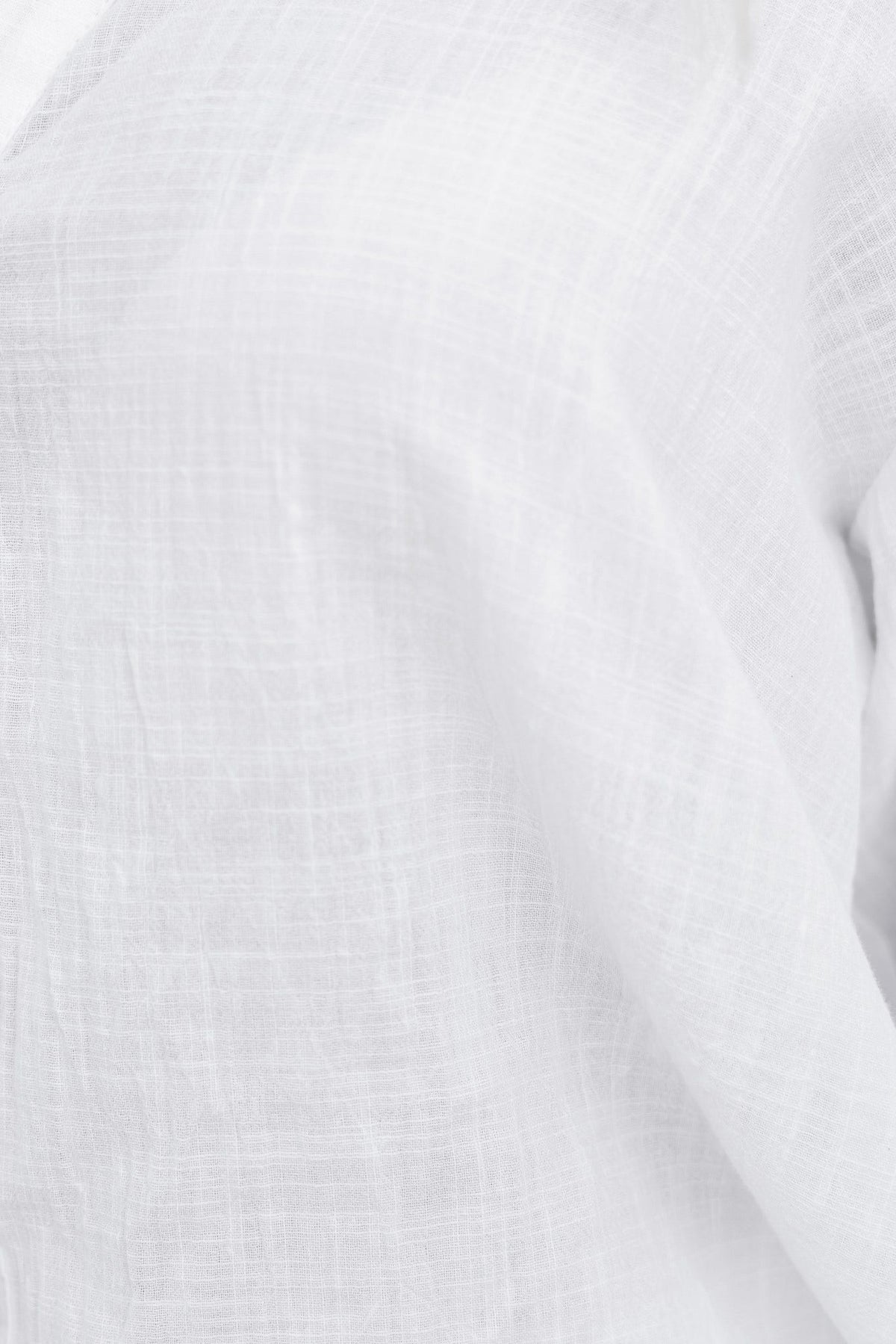 Close-up of the Oceania Shirt, showcasing its lightweight cotton fabric and button-up design in bright white.