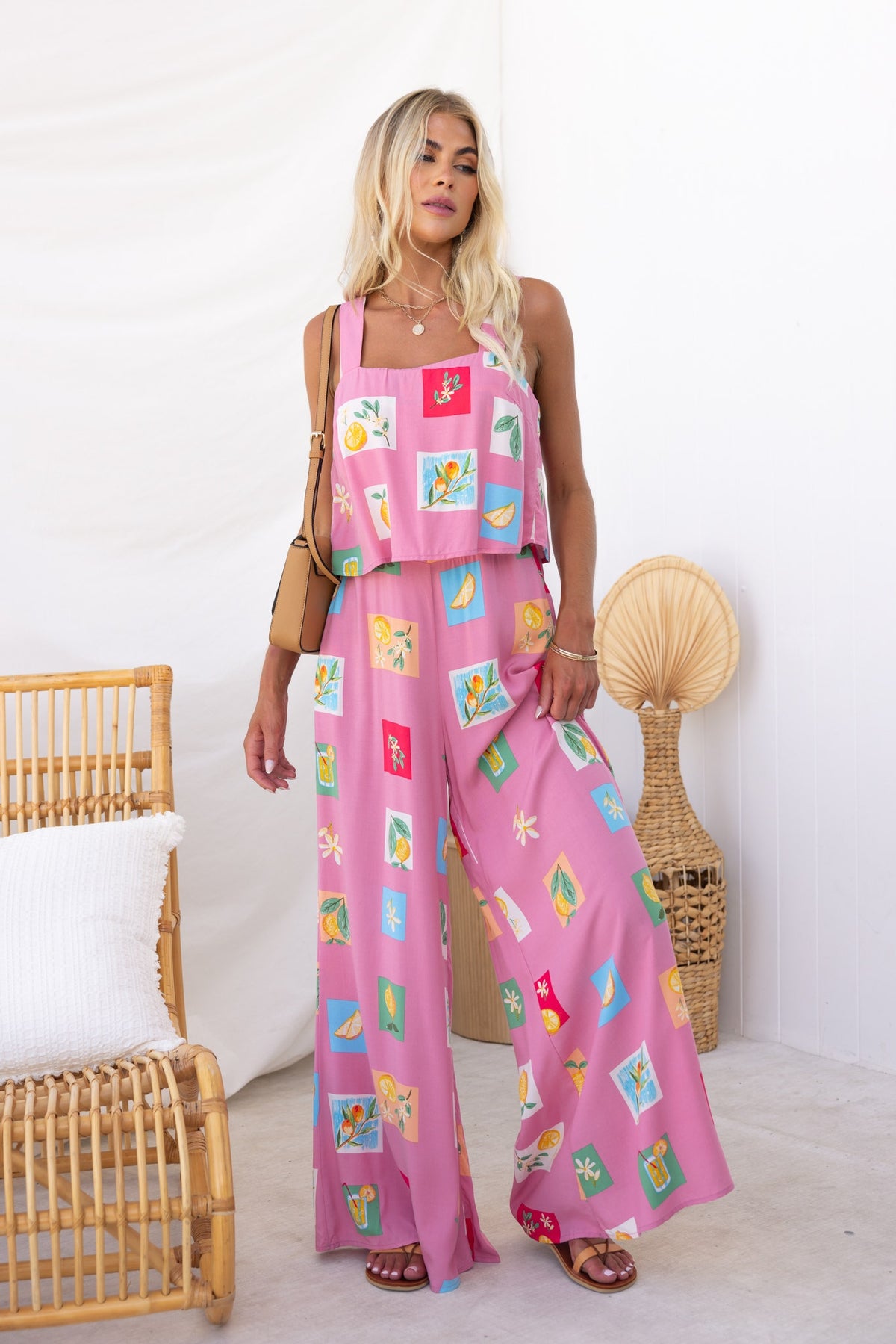 Model wearing Verko Jumpsuit, a pink abstract print jumpsuit with wide legs and pockets, ideal for a casual summer look.