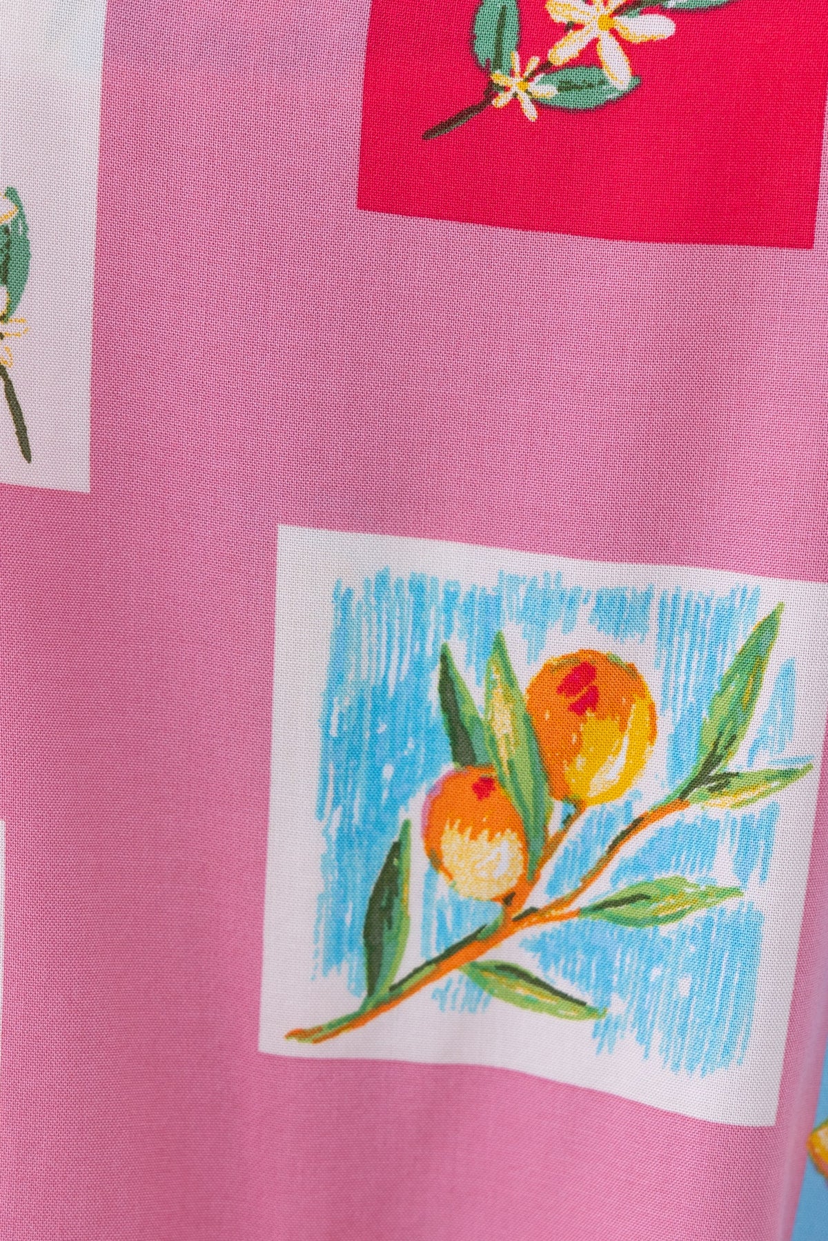Close-up of abstract floral and fruit print on fabric, featuring vibrant colors and intricate designs.