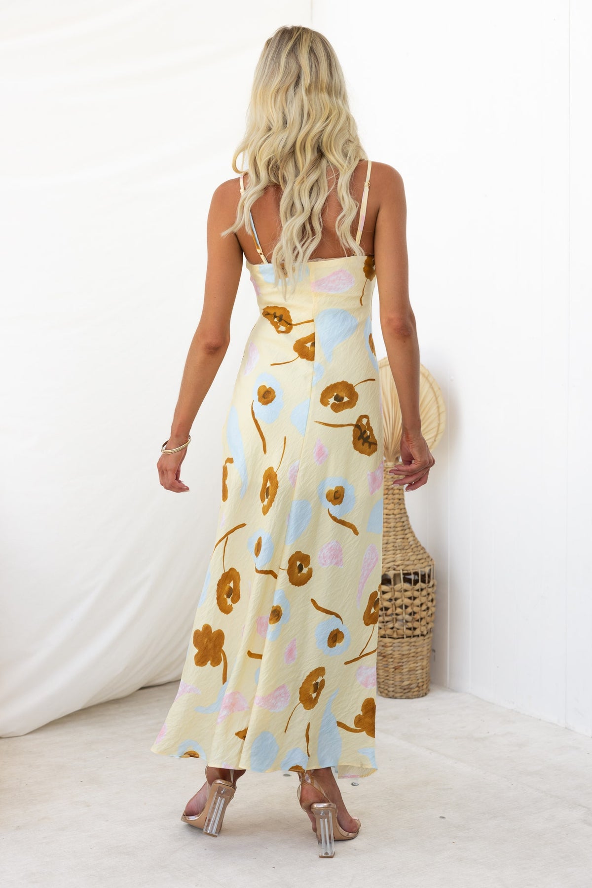 Back view of the Ellis Maxi Dress featuring floral print, adjustable straps, and a stylish split at the front.