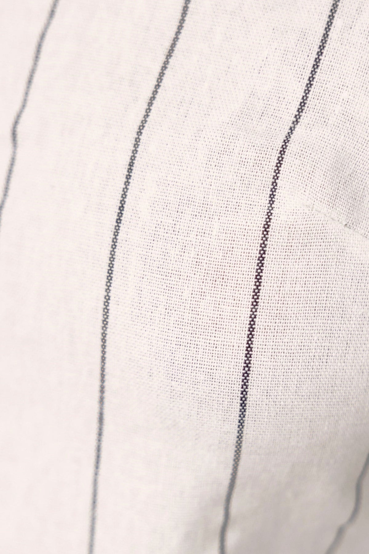 Close-up of striped linen top fabric, showcasing adjustable straps and lightweight design.