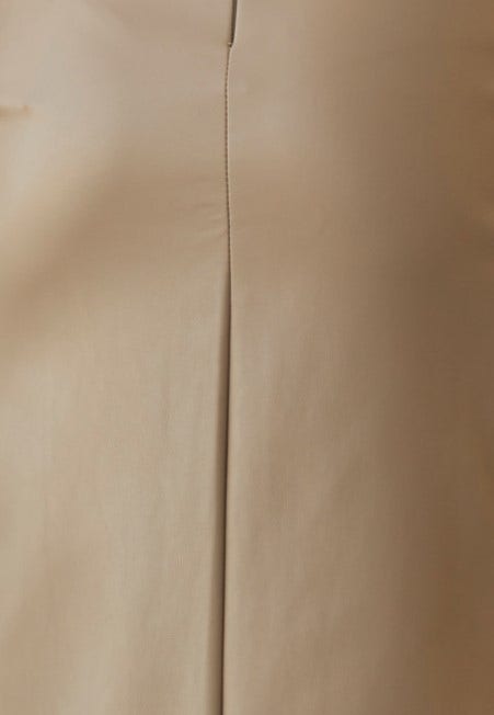 Close-up of Qorinda midi skirt's faux leather texture and seam detail, showcasing the elegant design and quality.