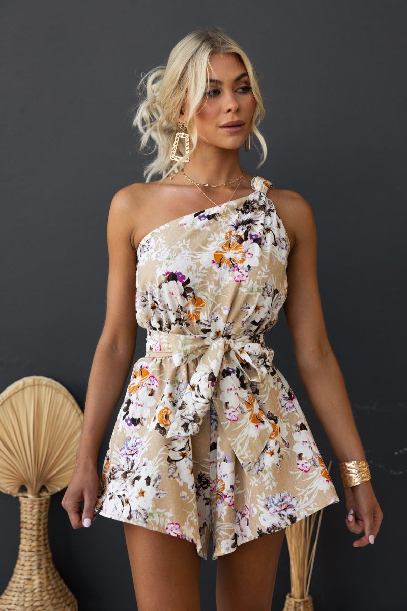Valetta Playsuit in beige floral print, featuring a one-shoulder neckline and removable belt for a stylish summer look.