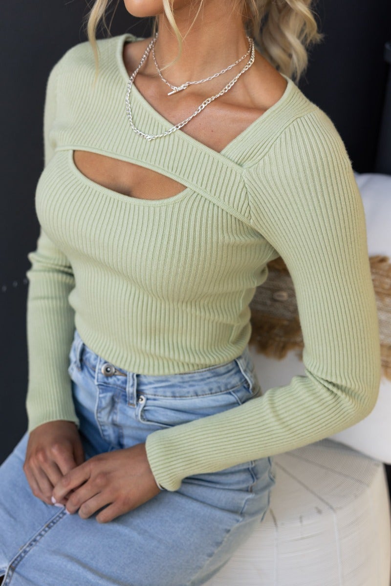 Daia Top in ribbed knit, featuring asymmetrical neckline and bust cut-out, modeled with denim jeans.