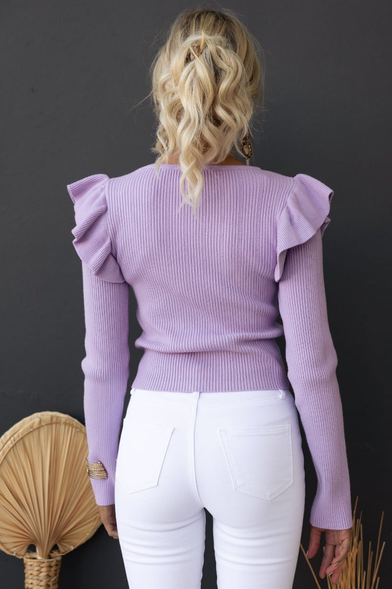 Back view of the Steph Top in lavender with ribbed texture and frill shoulder details, paired with white jeans.