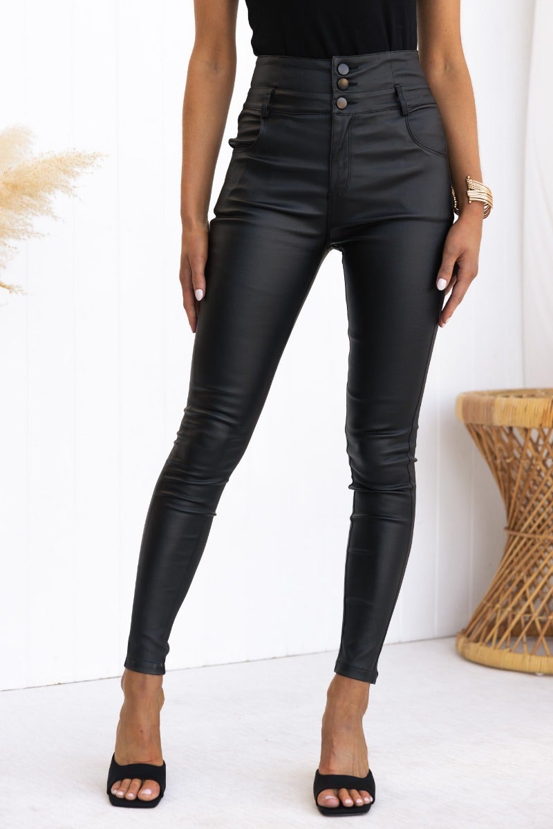 Leni Pants: Black faux leather mid-high waist pants with pockets, stretch material, and standard skinny fit.