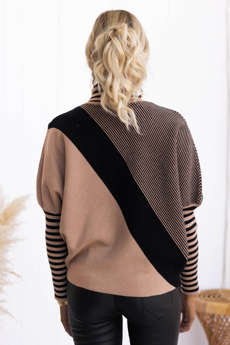 Back view of the Reality Check Jumper featuring ribbed material, turtle neckline, and batwing sleeves in beige and black.