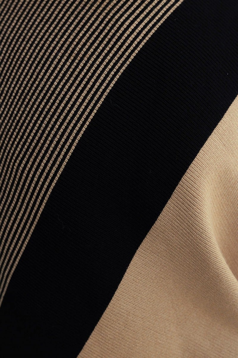Close-up of the Reality Check Jumper featuring ribbed knit fabric in black and beige with a turtle neckline.