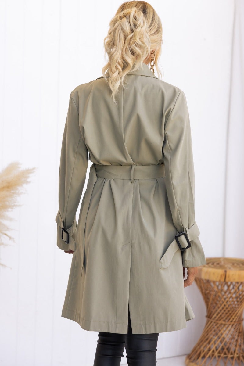 Back view of Cheyla Coat in olive green, featuring a removable fabric belt and buckle details on sleeve cuffs.