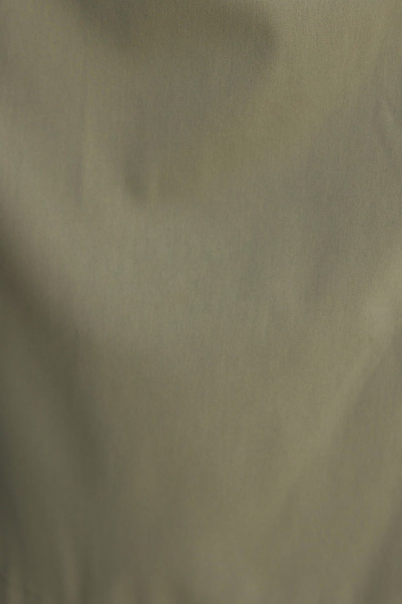 Close-up of textured fabric in khaki color, showcasing the durable composition for outdoor wear.