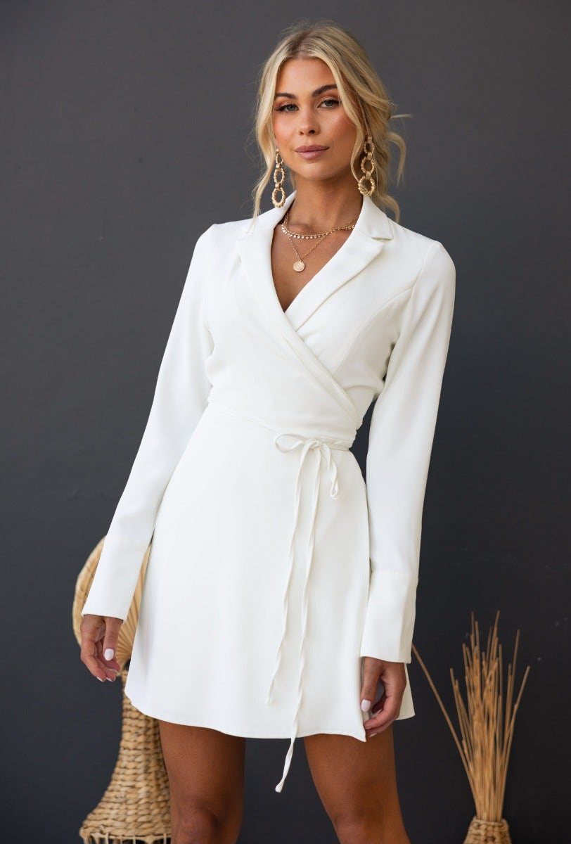 Model wearing a Valeria Wrap Dress with collar and attached fabric tie, styled in a clean white color.